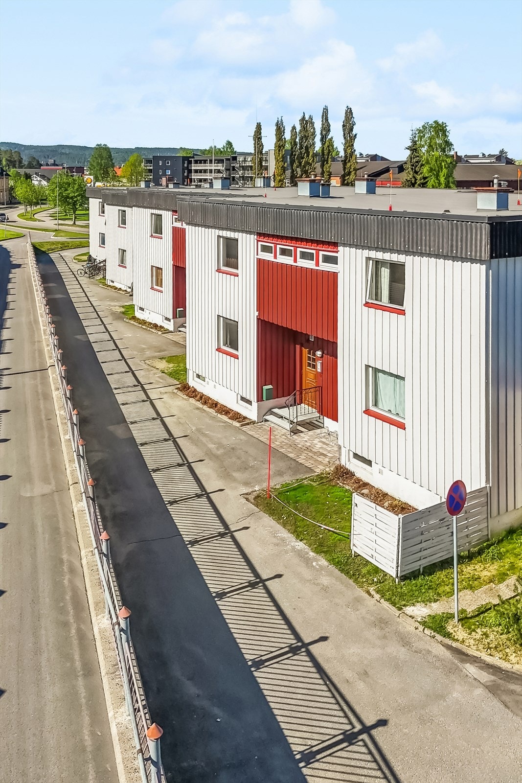 Fellestomten er opparbeidet med plen, noe beplantning og asfalterte veger og gangveger. Galleribilde