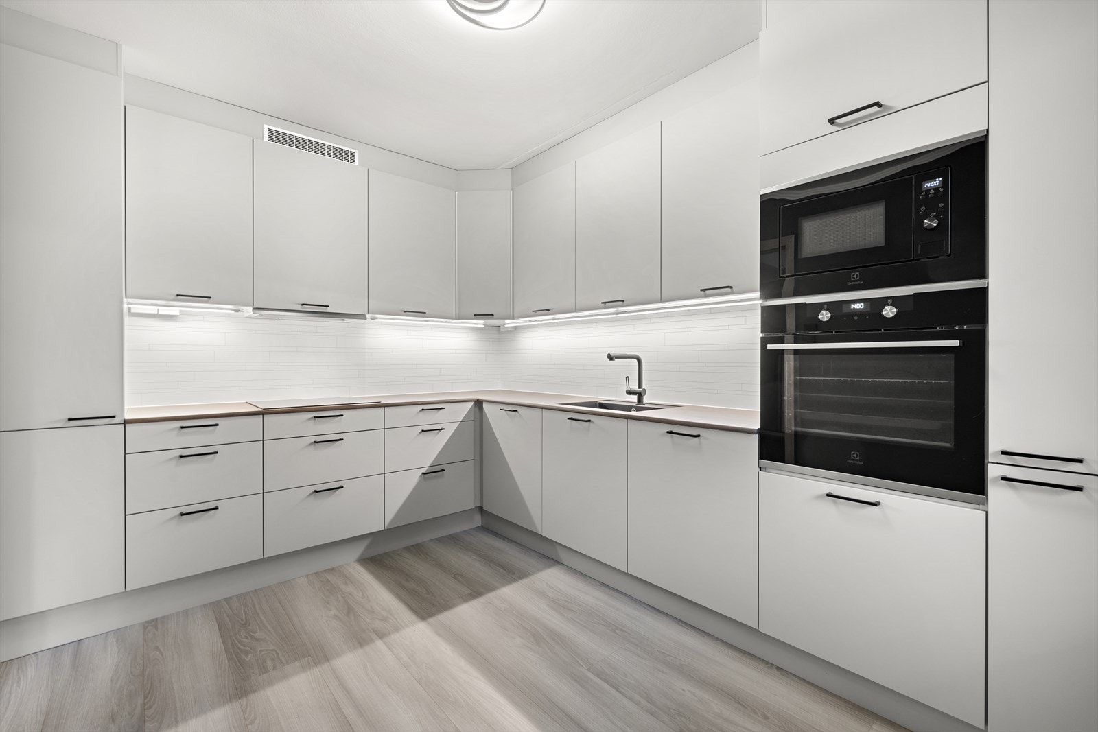 Moderne, lyst og stilfullt kjøkken med integrerte hvitevarer. Galleribilde