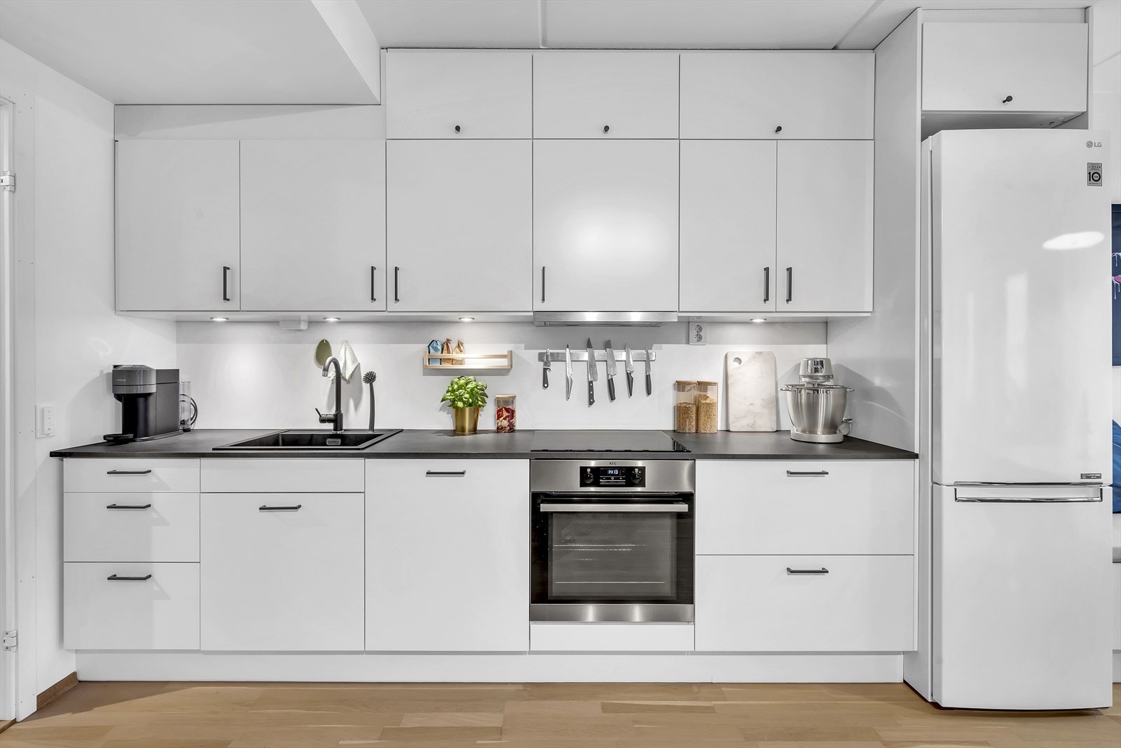 Integrerte hvitevarer består av platetopp, stekeovn og oppvaskmaskin med automatisk åpning etter vask samt frittstående kjøleskap. Galleribilde