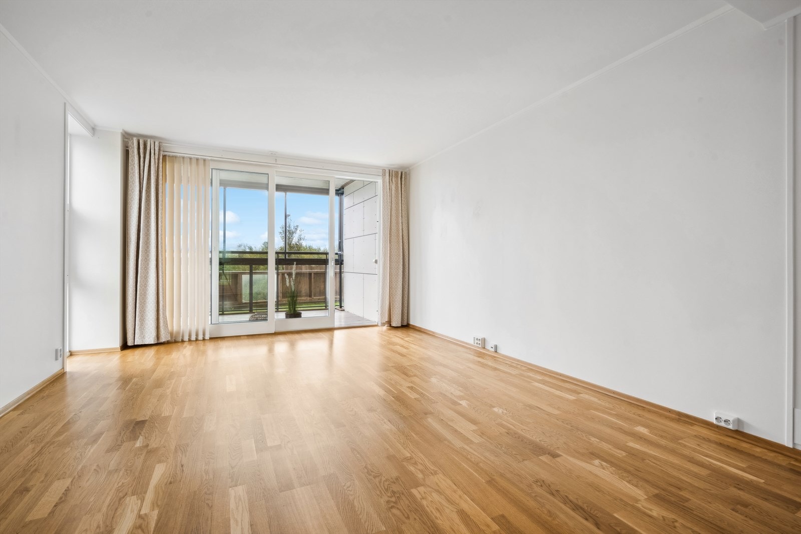 Leiligheten har en lys og luftig stue med store vinduer og lyse overflater. Galleribilde
