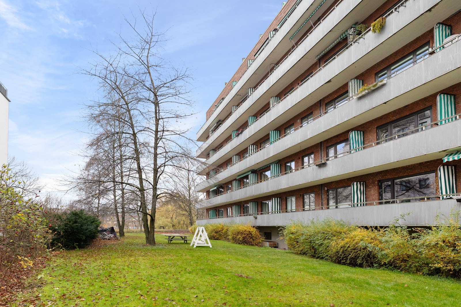 Tomten er pent opparbeidet med asfalterte internveier og parkeringsplasser, diverse beplantninger samt plenarealer Galleribilde