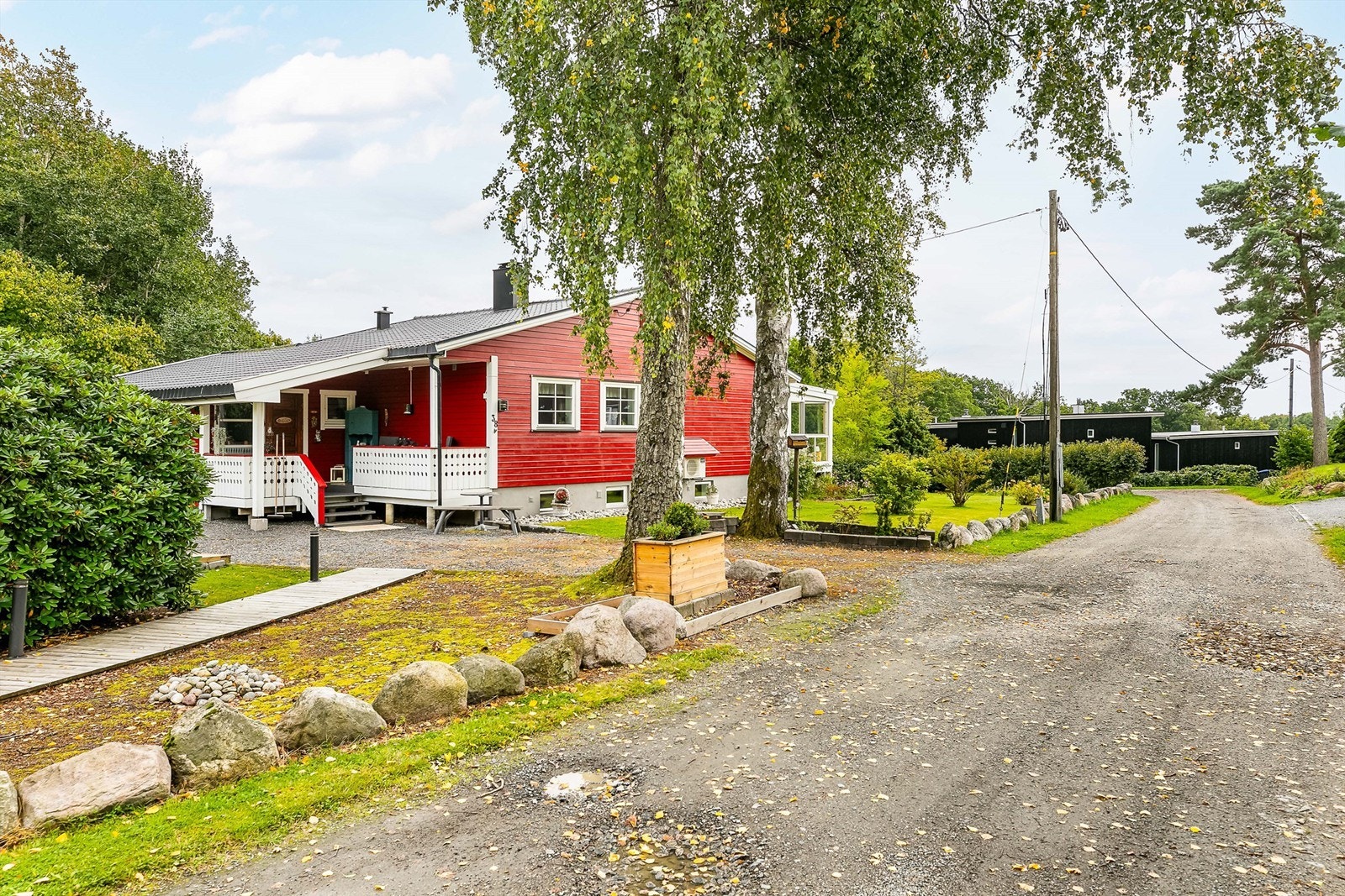 Lyssatt gangvei leder mellom garasjen og gårdsplassen. Galleribilde