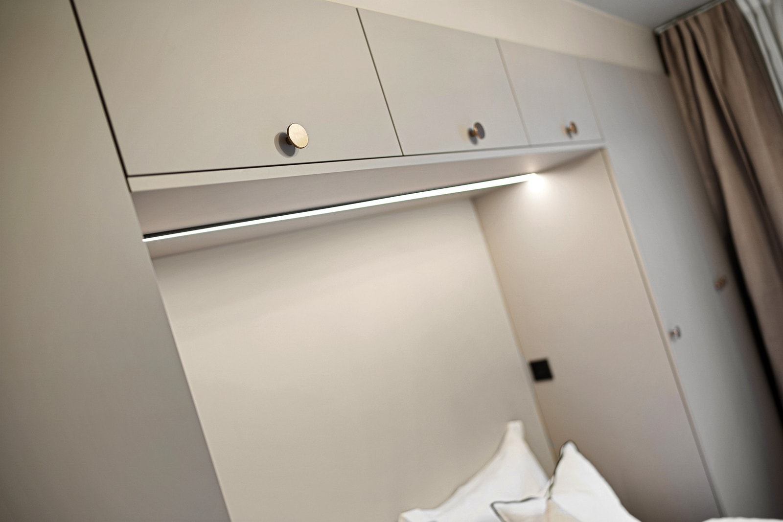 Moderne belysning med store lamper i stue og hovedsoverom, LED-stripe over seng og på kjøkken, og dobbel spotbelysning på bad Galleribilde