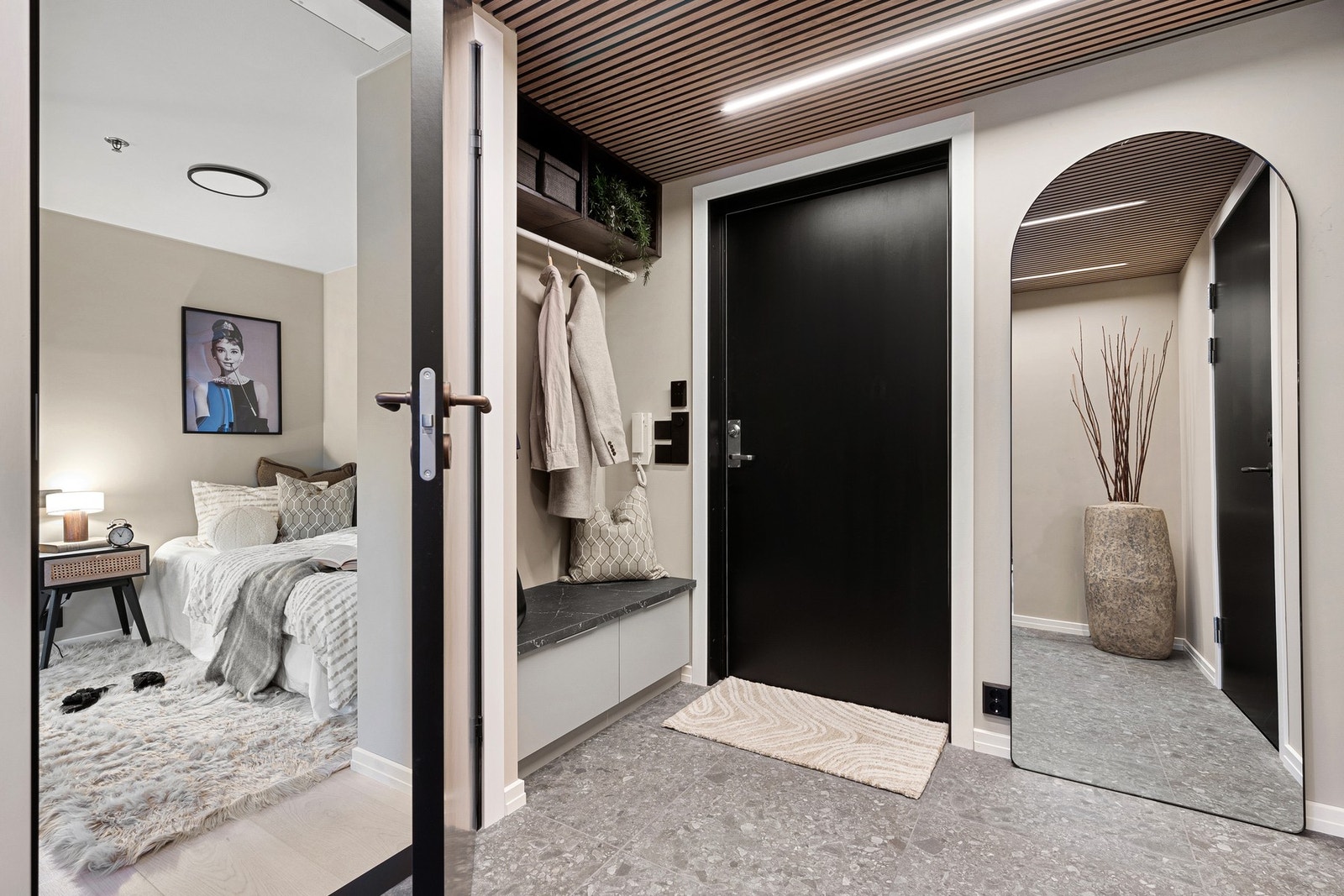 Flislagt og romslig gang med akustikkpanel i eik i taket med integrerte LED-striper Galleribilde