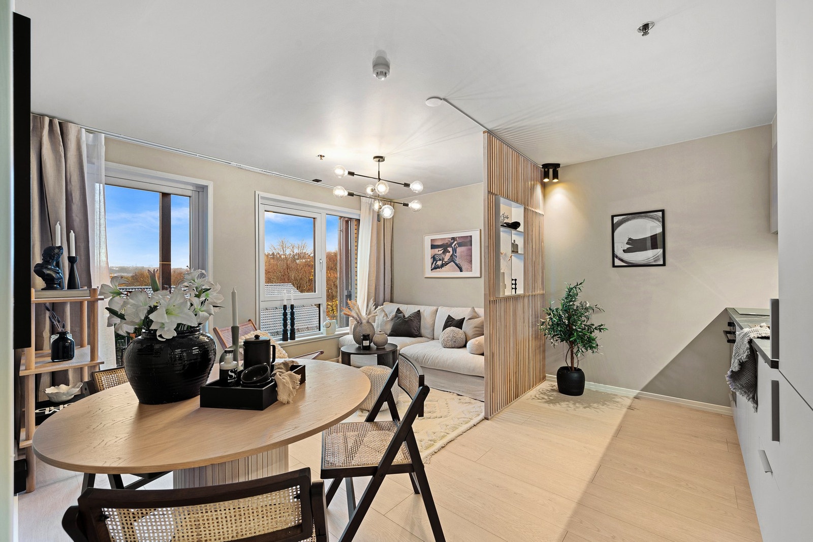 Stuen er av fin størrelse og har åpen spilevegg i heltre eik som skiller stue og kjøkken med dobbel downlight-belysning Galleribilde