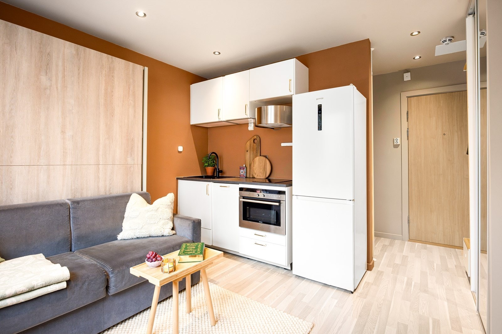 Moderne og stilren kjøkkeninnredning med glatte, laminerte fronter, laminert benkeplate, kum med ettgreps blandebatteri og kullfiltervifte over integrert koketopp (to plater), integrert ovn og integrert oppvaskmaskin. Galleribilde