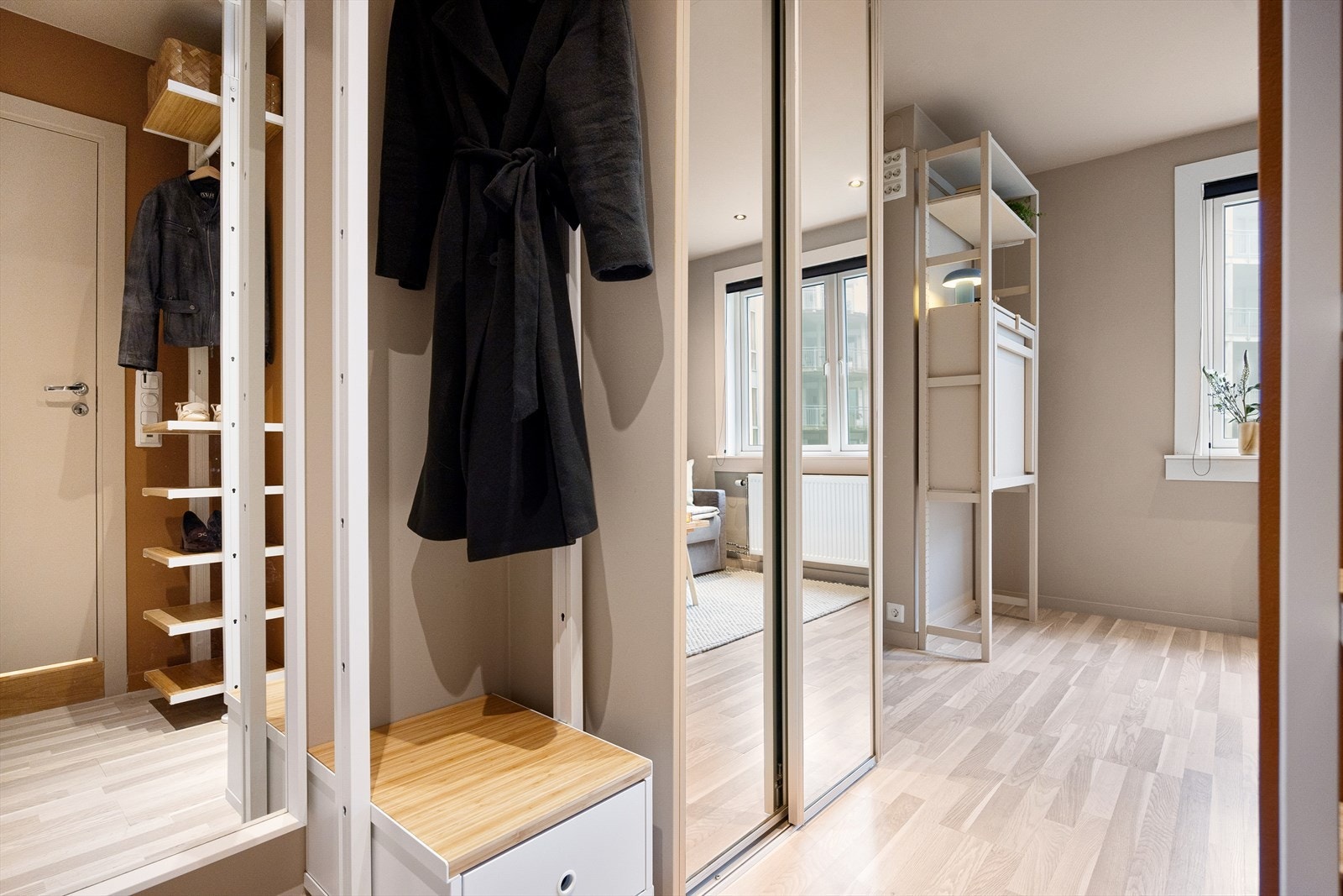 Åpen entré med plass til ytterklær og sko i romslig skyvedørsgarderobe. Galleribilde