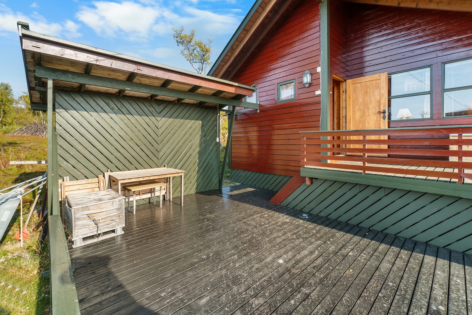 Utenfor er det en stor platting som omkranser hytta. Galleribilde