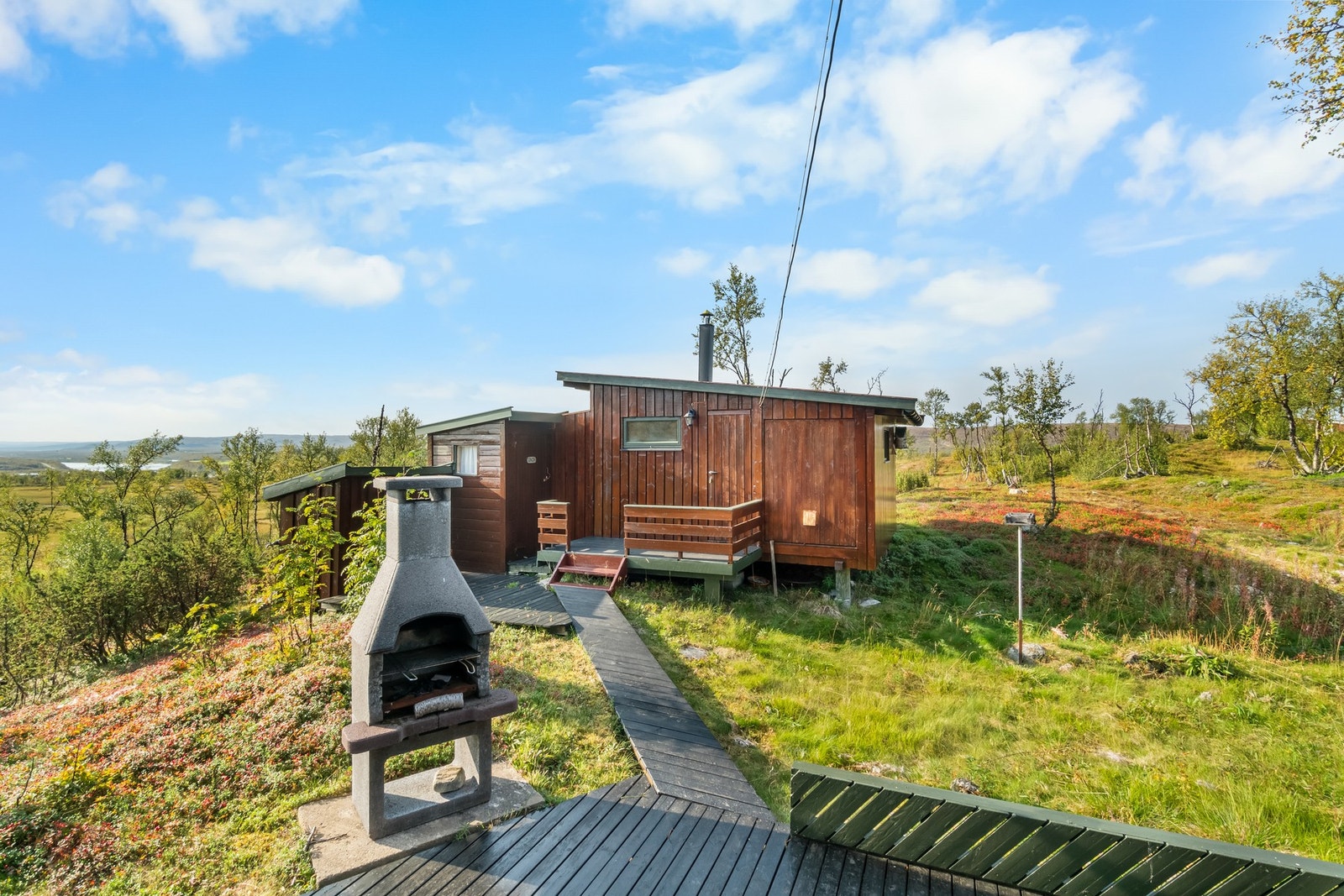 Platten sammenkobler hytta og annekset. På sommerstid kan man fint gå tørrskodd mellom bygningene. Galleribilde