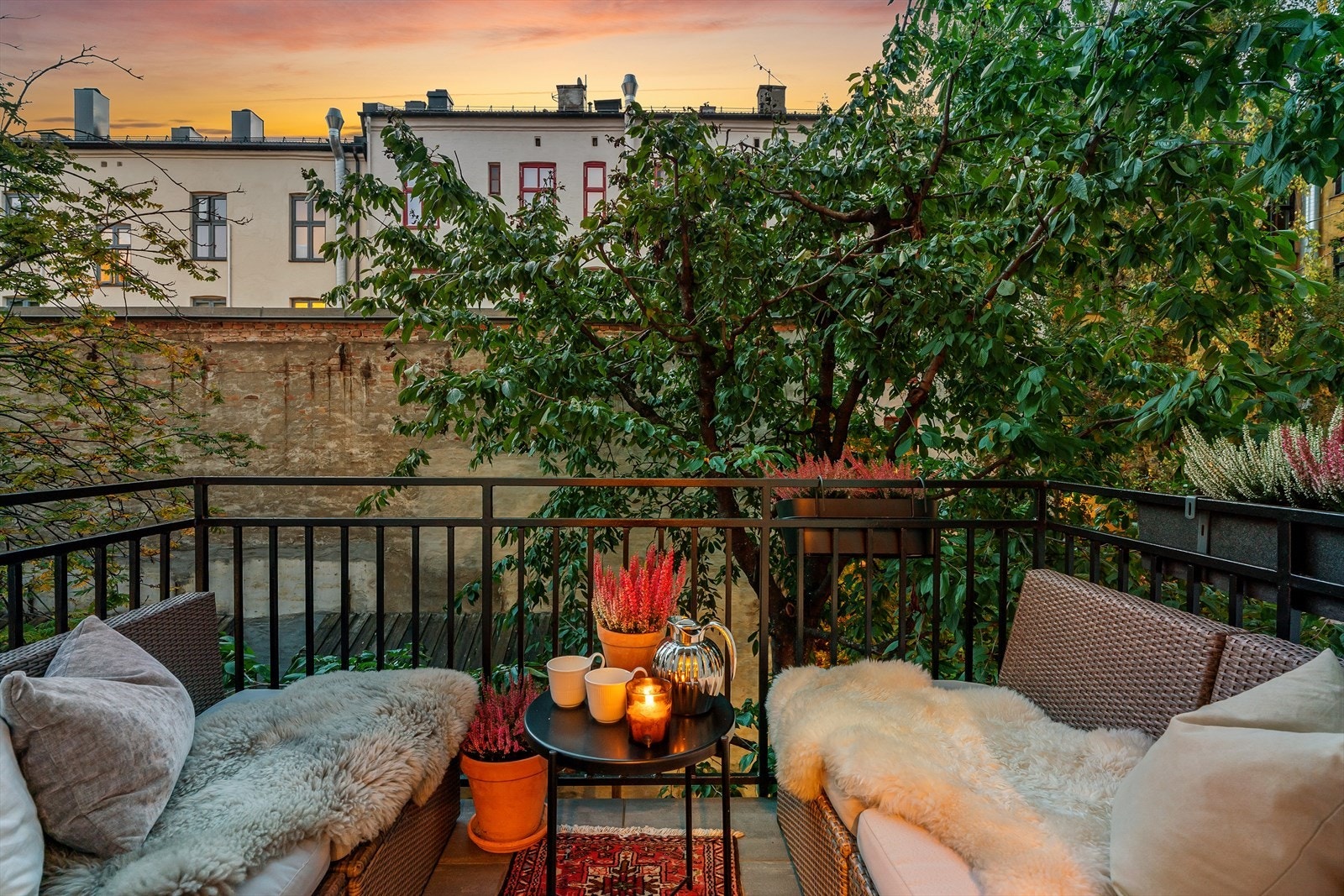 Kveldsstemning på balkongen mot frodig, rolig bakgård. Galleribilde