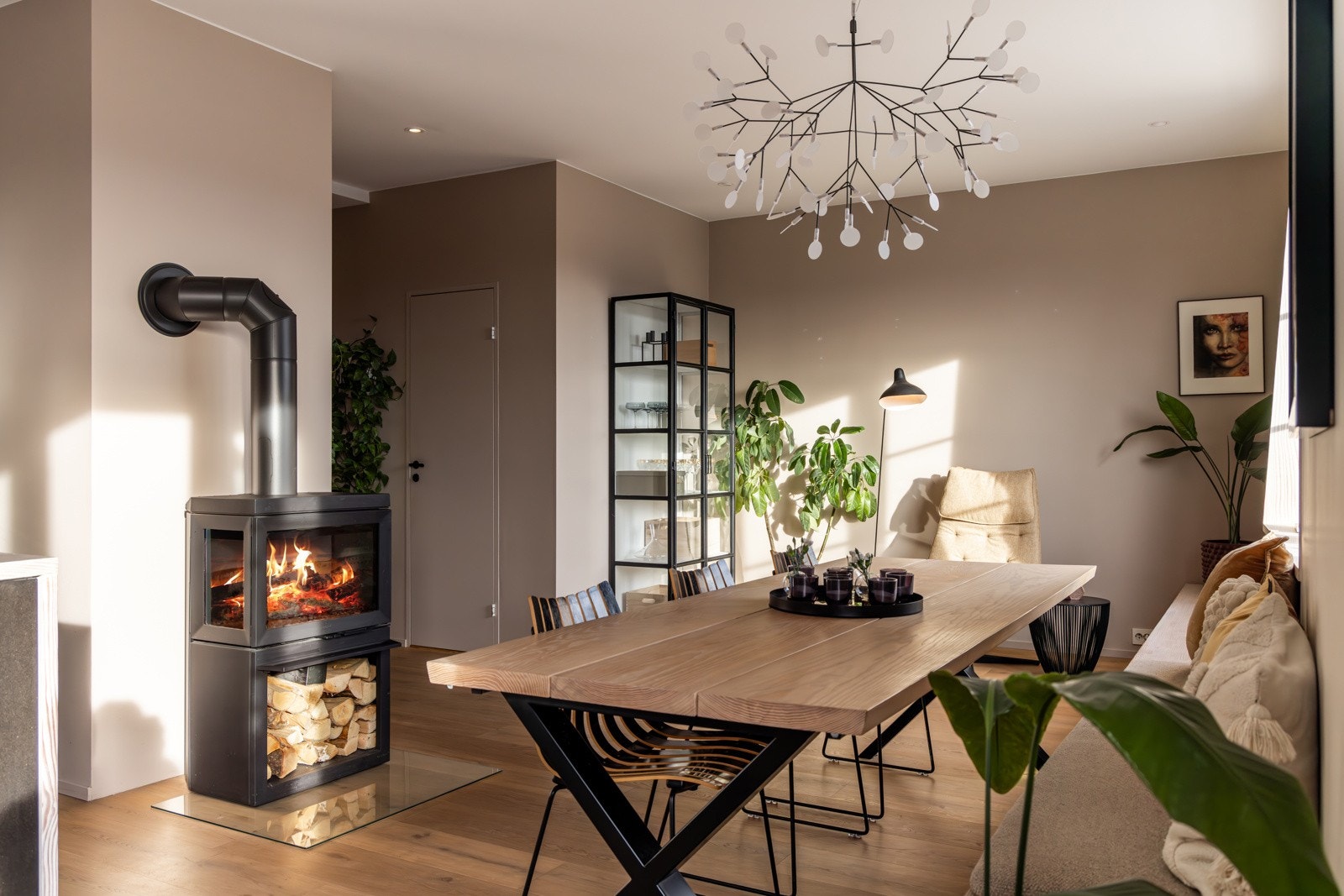 Her er det rikelig med plass til både sofagruppe, tilhørende møbler og spisebord, og en stemningsfull peisovn tilfører varme og hygge Galleribilde