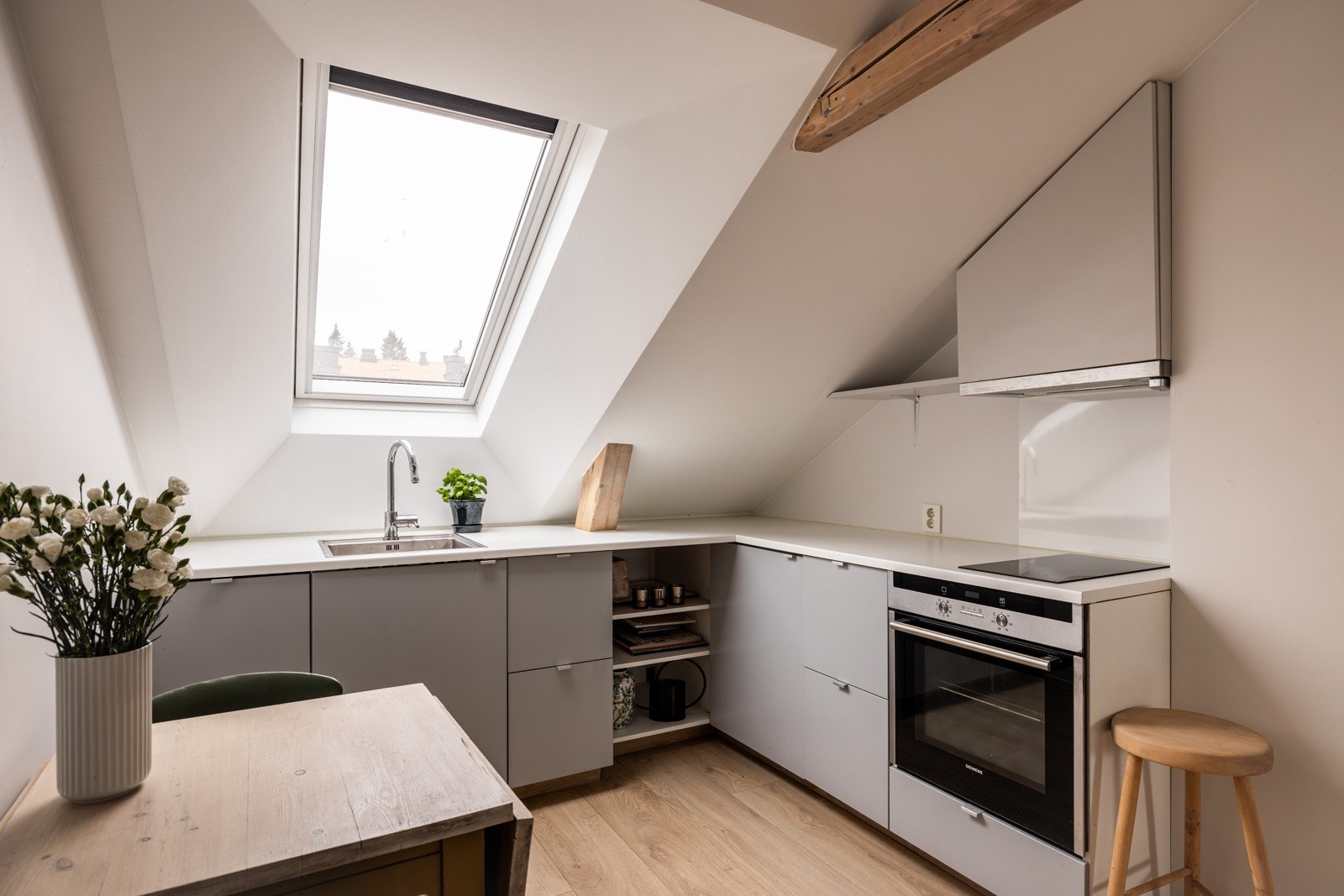 Hybelen er utstyrt med et funksjonelt kjøkken med slette, malte fronter og stilrene stålgrep Galleribilde