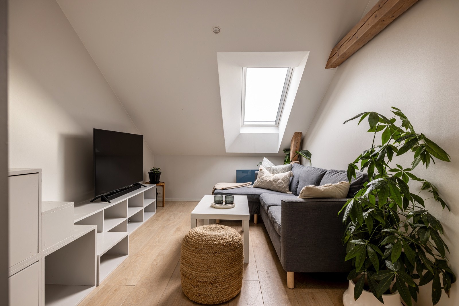 Stuen ligger i delvis åpen løsning med kjøkkenet og har plass til en sofa og tilhørende møbler Galleribilde