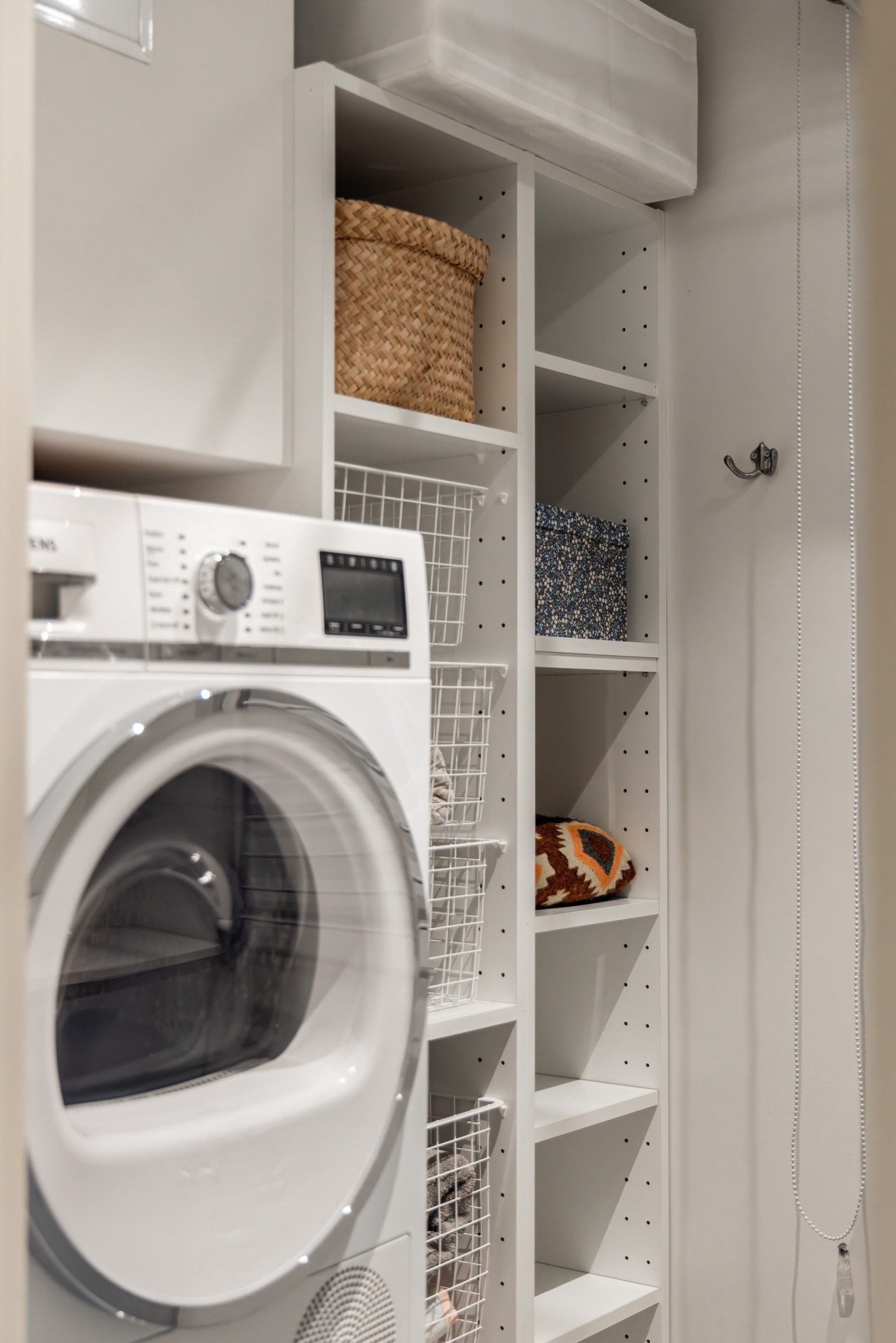 Praktisk plassering av vaskemaskin, samt hylleløsning som sikrer godt med oppbevaringsplass Galleribilde