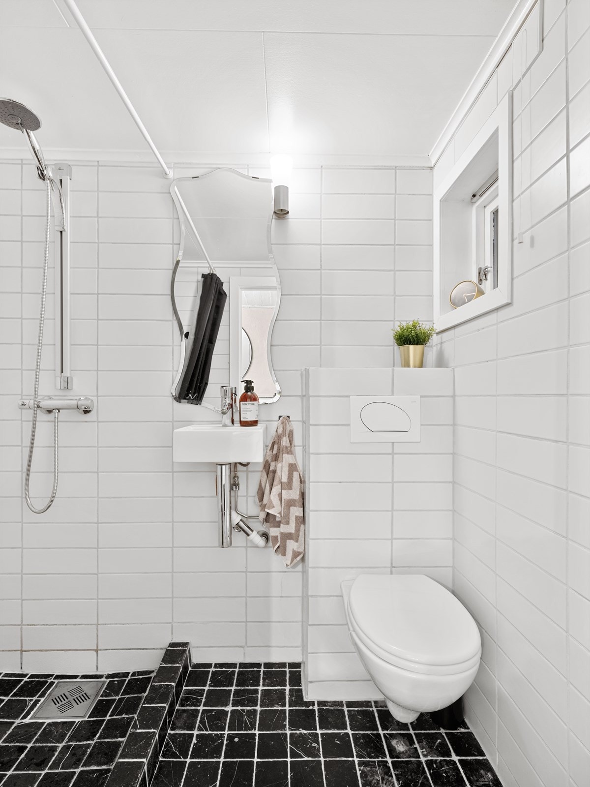 Helfliset bad med dusj, vask og vegghengt toalett. Galleribilde