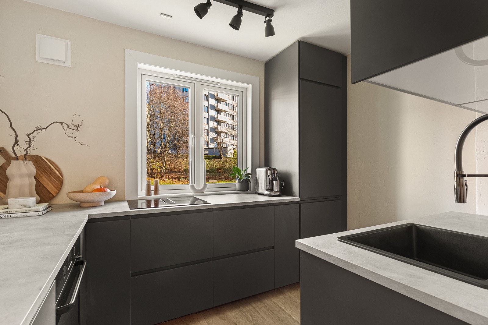 Leiligheten har et separat kjøkken med stilren kjøkkeninnredning fra 2023 og nydelig utsikt mot borettslagets store grøntarealer. Galleribilde