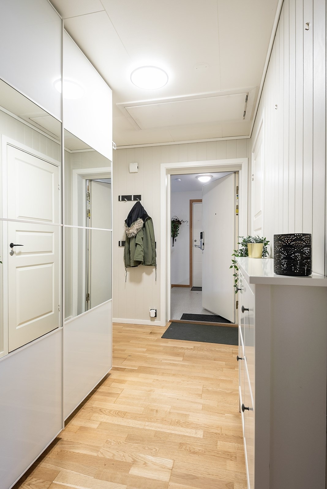 Stor og innbydende entré med plass til å henge fra seg yttertøy og sette fra seg sko i en praktisk skyvedørsgarderobe. Galleribilde