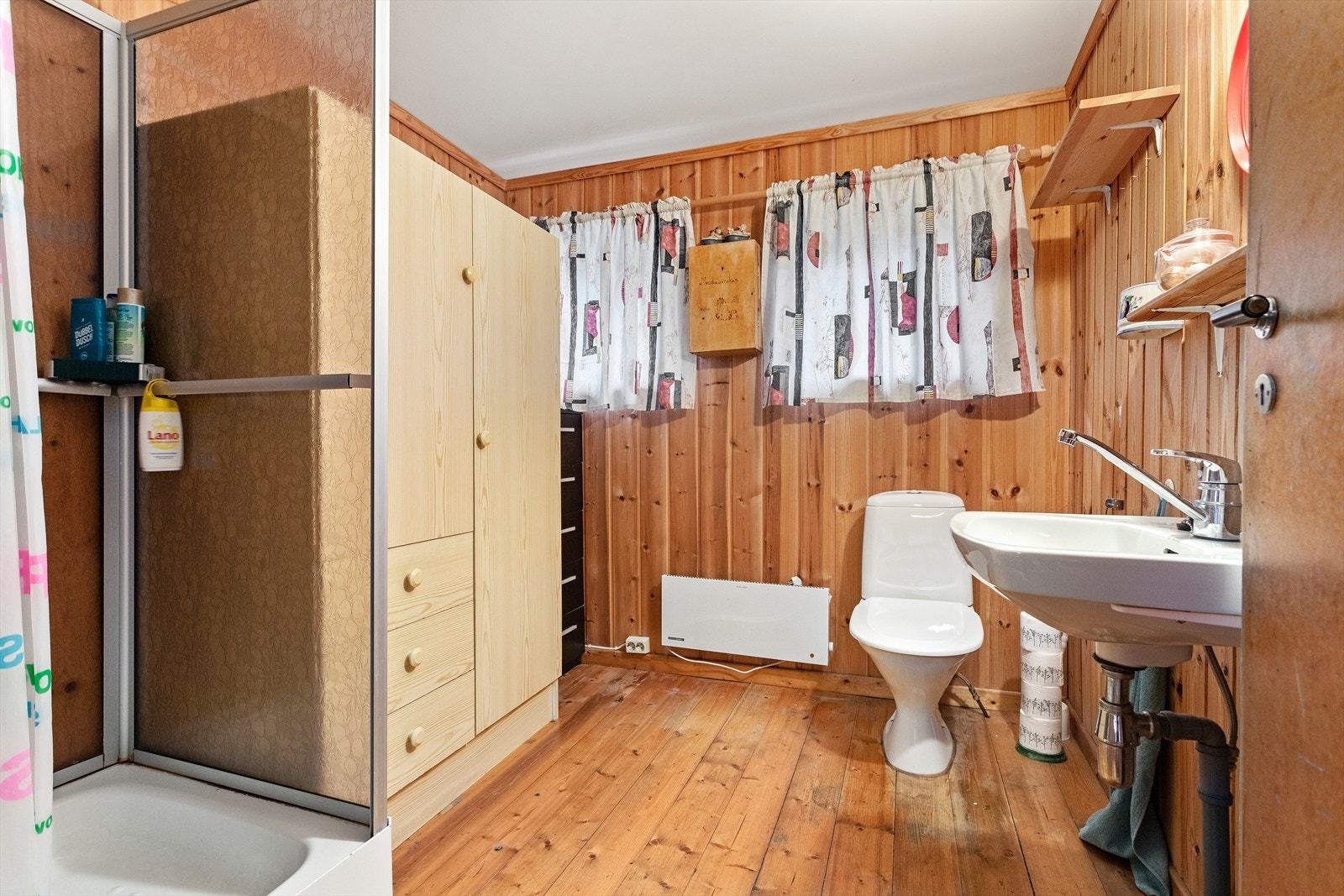 Badet har furugolv og veggar av trepanel. I taket er det måla plater. Galleribilde