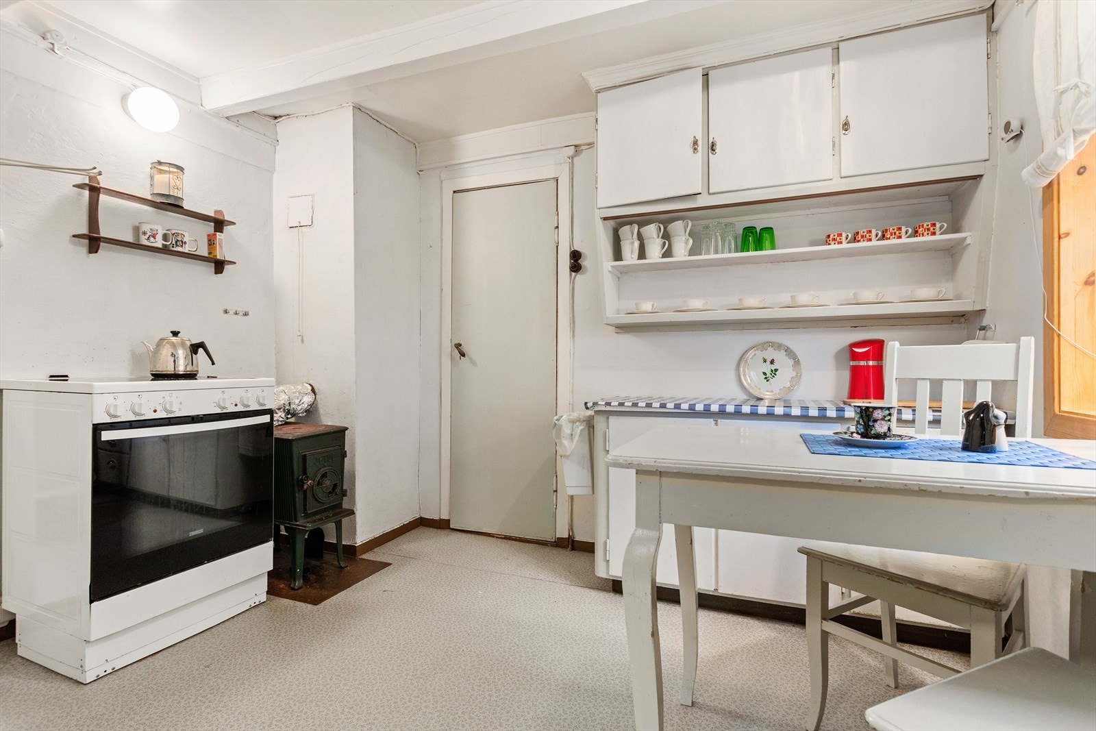 Kjøkenet er av eldre type med enkel innreiing og komfyr. Galleribilde