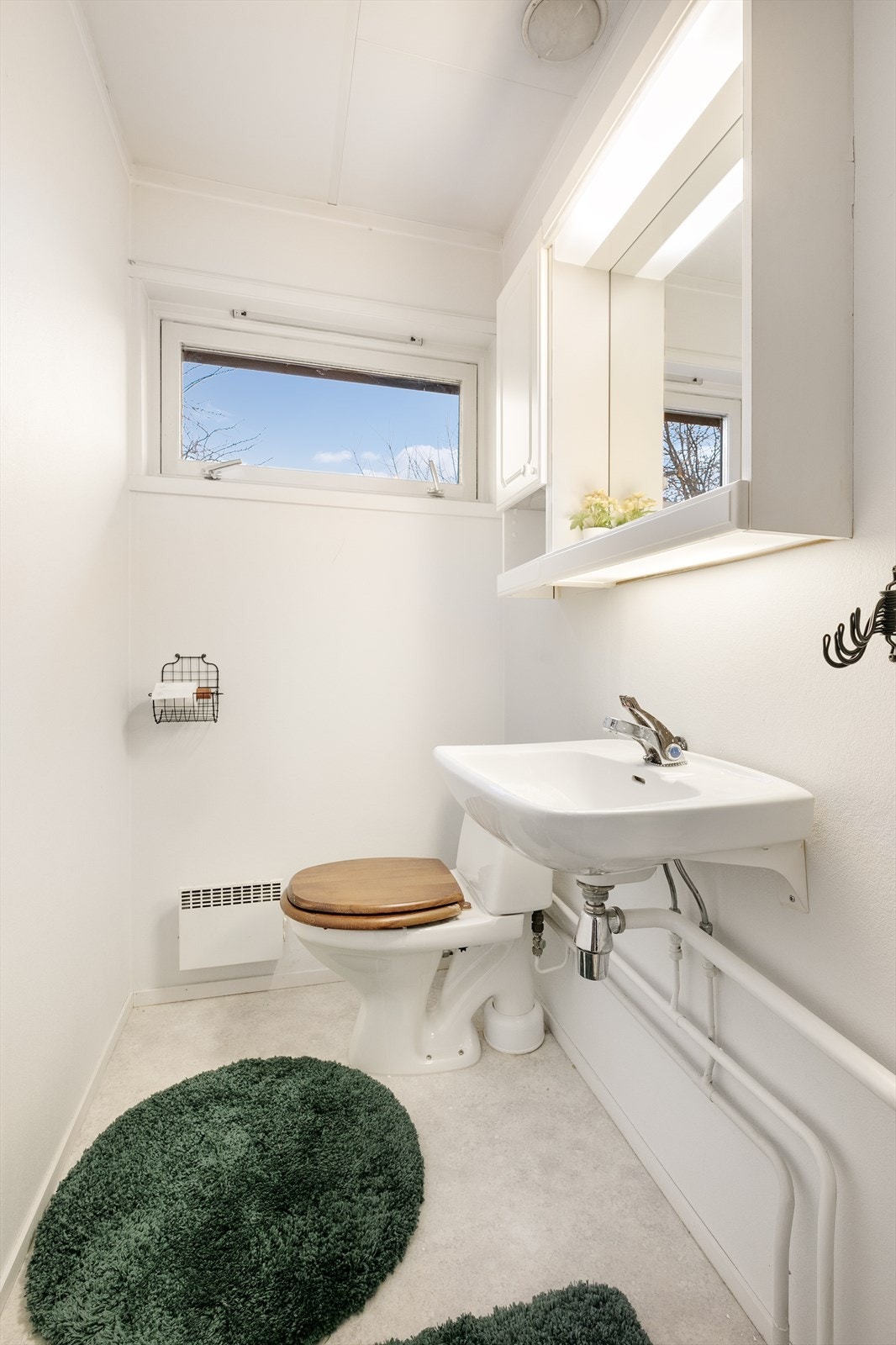 Separat wc med linoleum på gulv, servant, speil, overskap og gulvmontert toalett Galleribilde