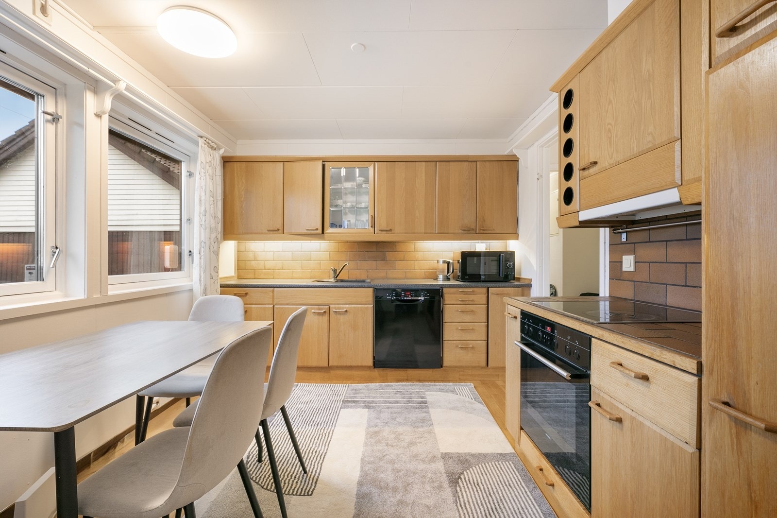 Kjøkkenet har innredning med laminerte skrog og profilerte fronter i heltre, samt laminat benkeplate med nedfelt oppvaskkum og integrerte hvitevarer Galleribilde