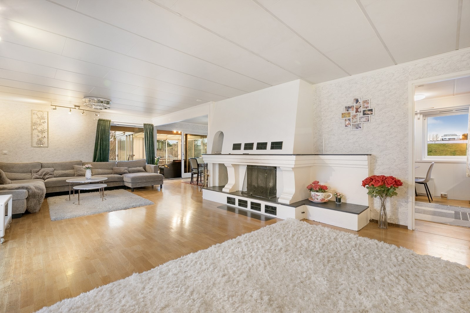 Lys og romslig stue med god plass til både sofa- og spiseseksjon og andre møblementer Galleribilde