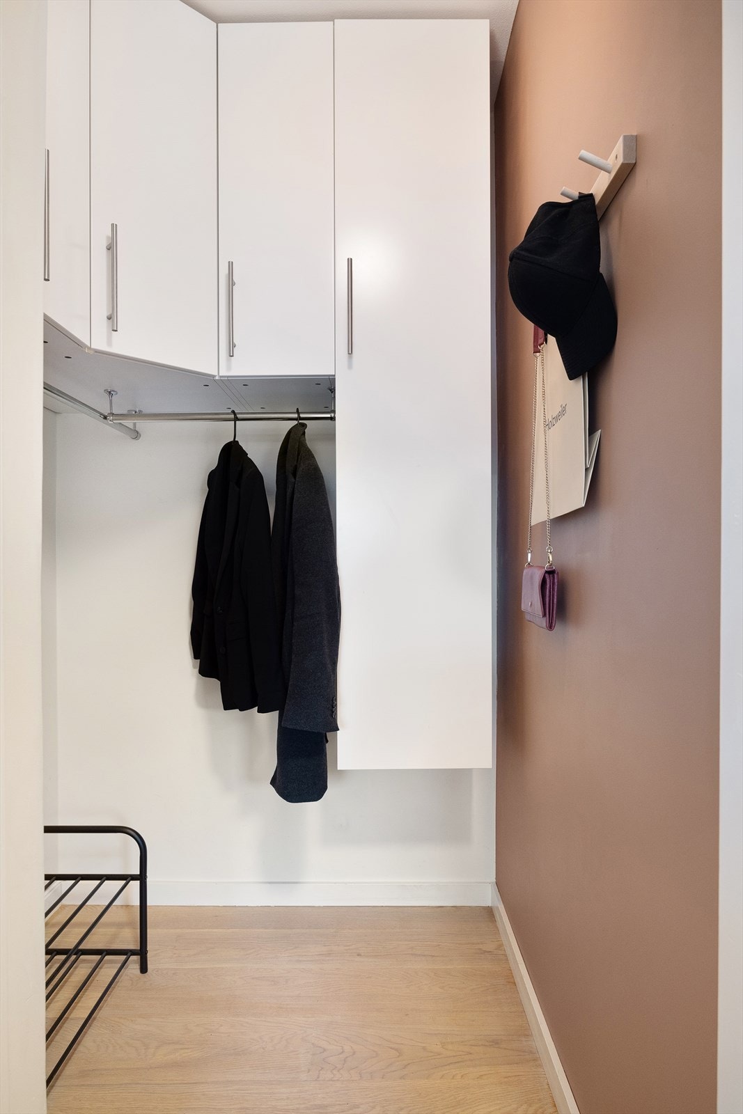 Garderoben er utstyrt med vegghengte skap, skinner for jakker og knagger på veggen. Galleribilde