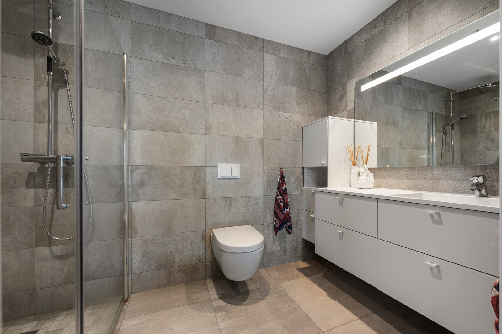 Tilhørende hovedsoverommet er et helfliset bad med lekker innredning. Galleribilde