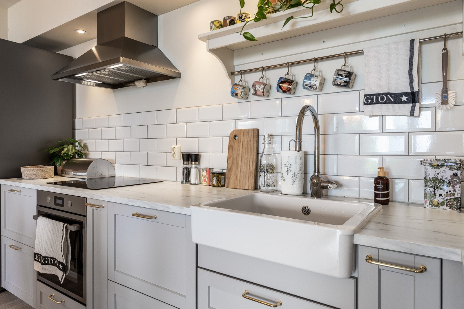 Innredningen fra Ikea har lysegrå, profilerte fronter og lys laminatbenkeplate i marmor-look med en stor, hvit oppvaskkum i porselen. Galleribilde