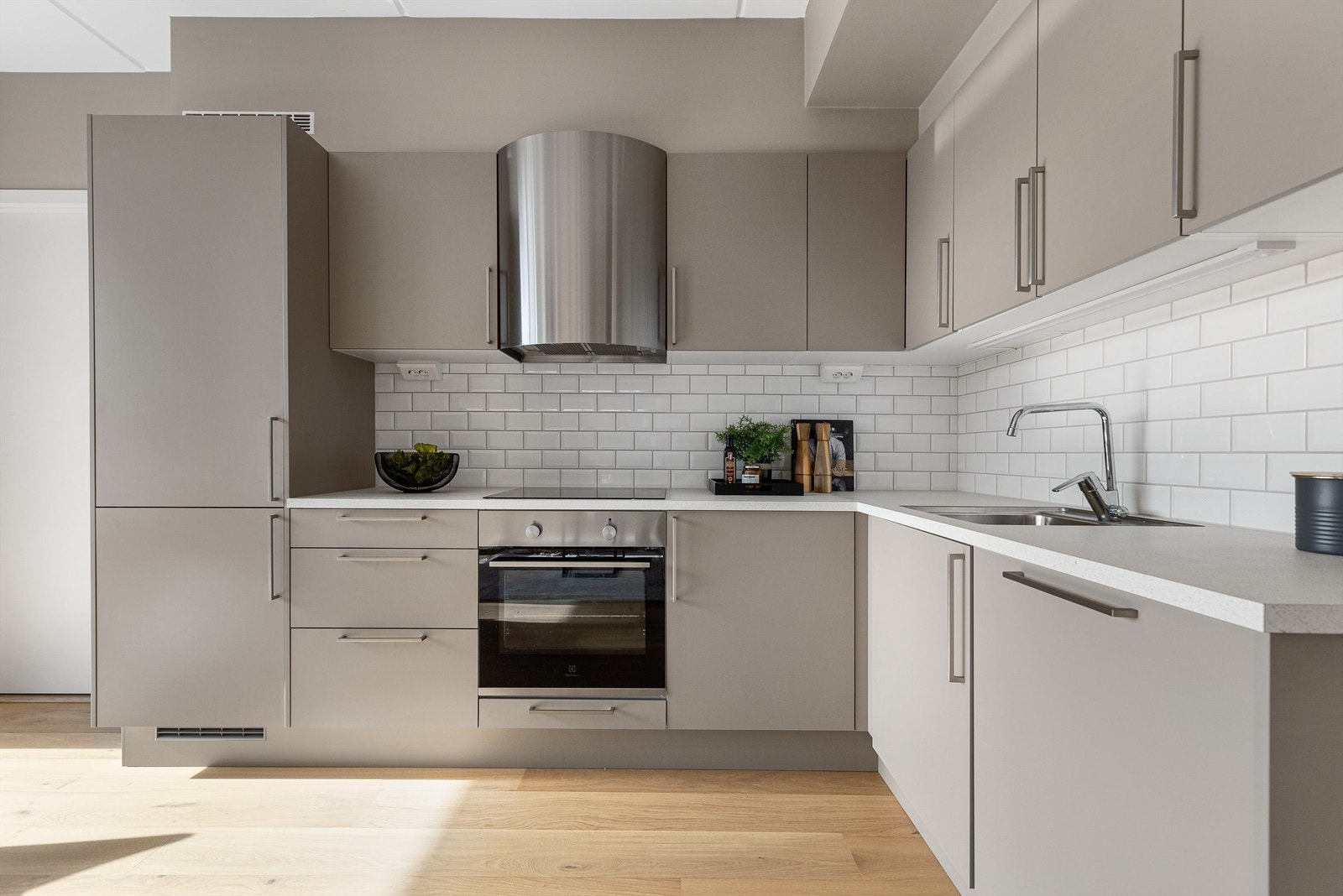 Kjøkkenet ligger naturlig tilbaketrukket fra stuen og er innredet med lyse slette flater og benkeplate av laminat. Galleribilde