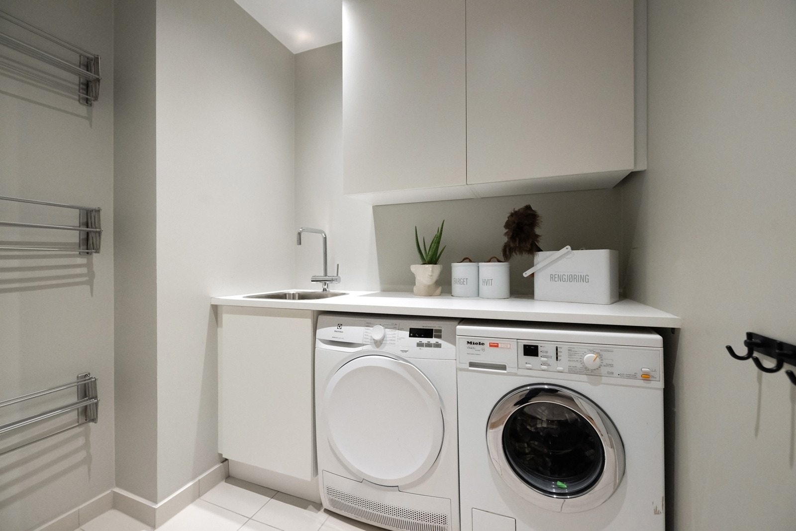 Vaskerommet har flislagt gulv, vannbåren varme, avtrekk og downlights. Opplegg for vaskemaskin og tørketrommel. Galleribilde