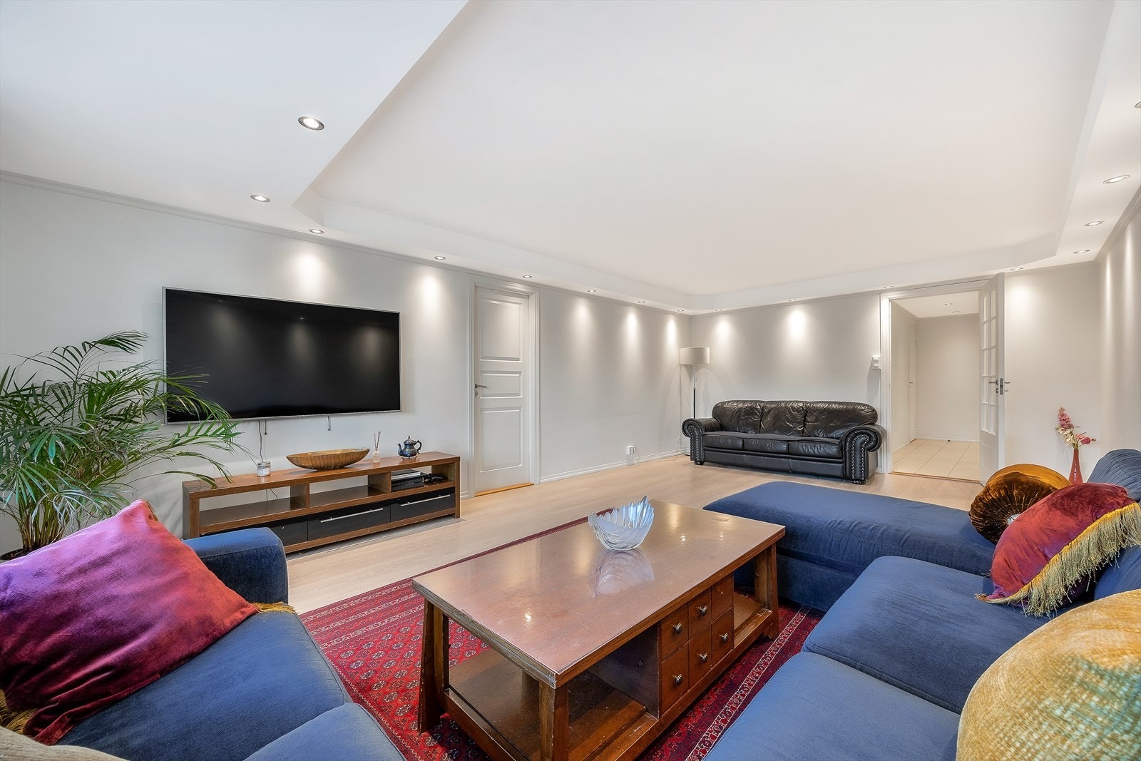 Overflatene er hvitmalte og gulvet er belagt med parkett Galleribilde