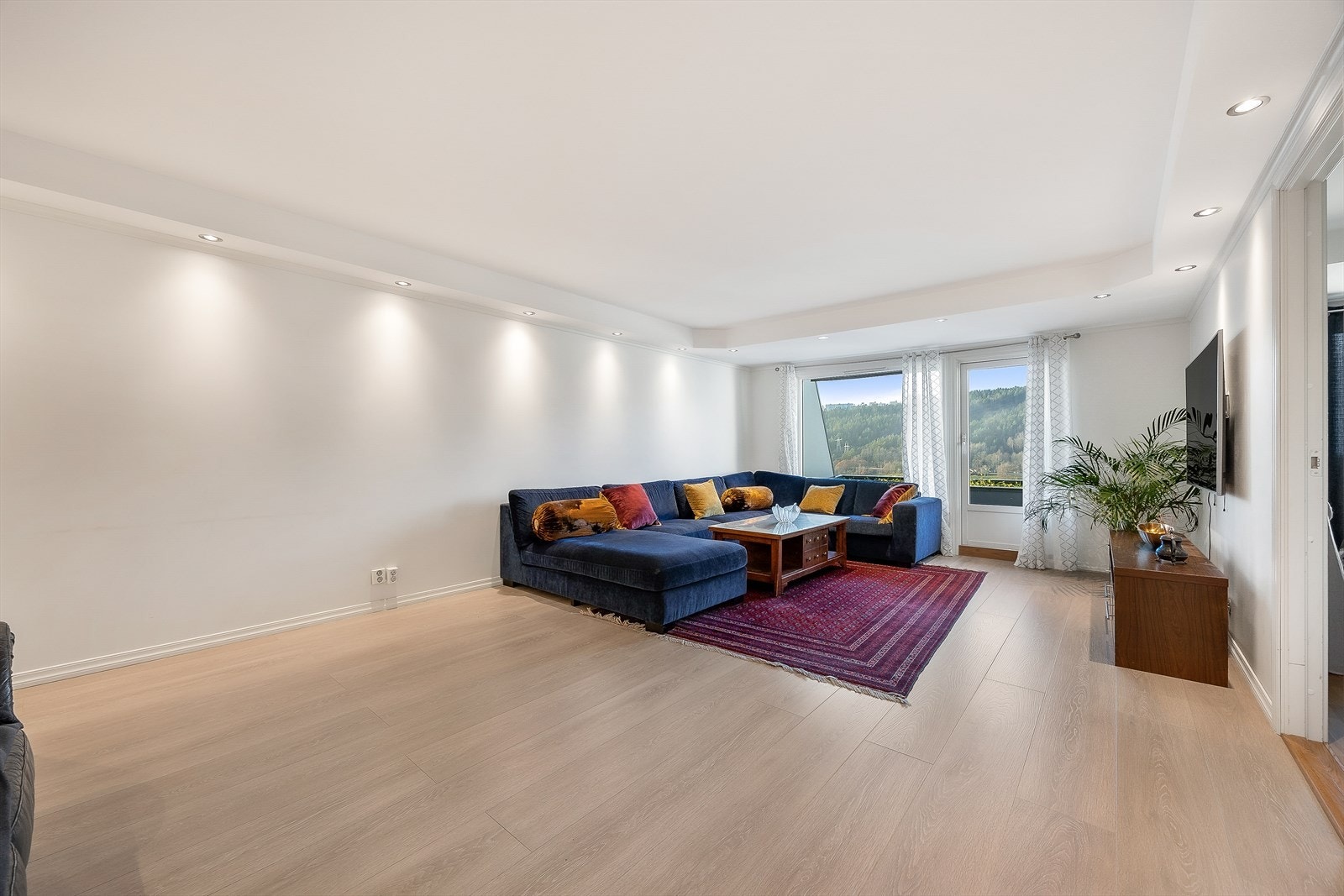 Med gjennomgående løsning og store vinduer oppleves stuen som lys og luftig Galleribilde