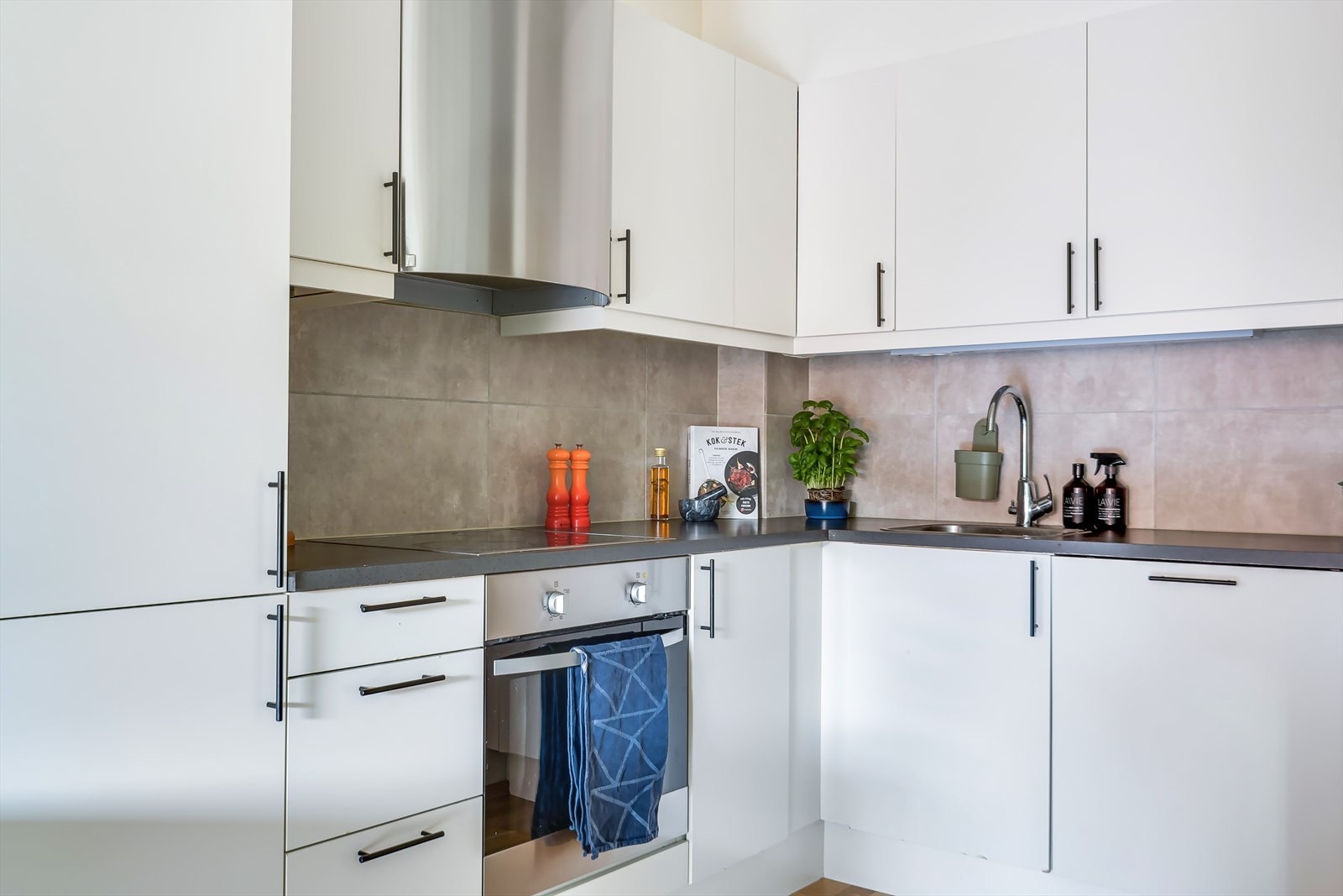 Det er laminert benkeplate med nedfelt oppvaskkum, og fliser mellom overskap og benkeplate. Galleribilde