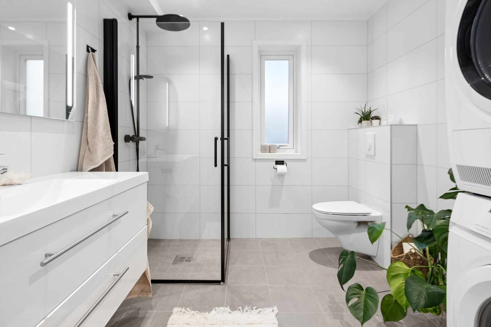 Flislagt baderom som har varmekabler samt opplegg for vaskemaskin. Galleribilde