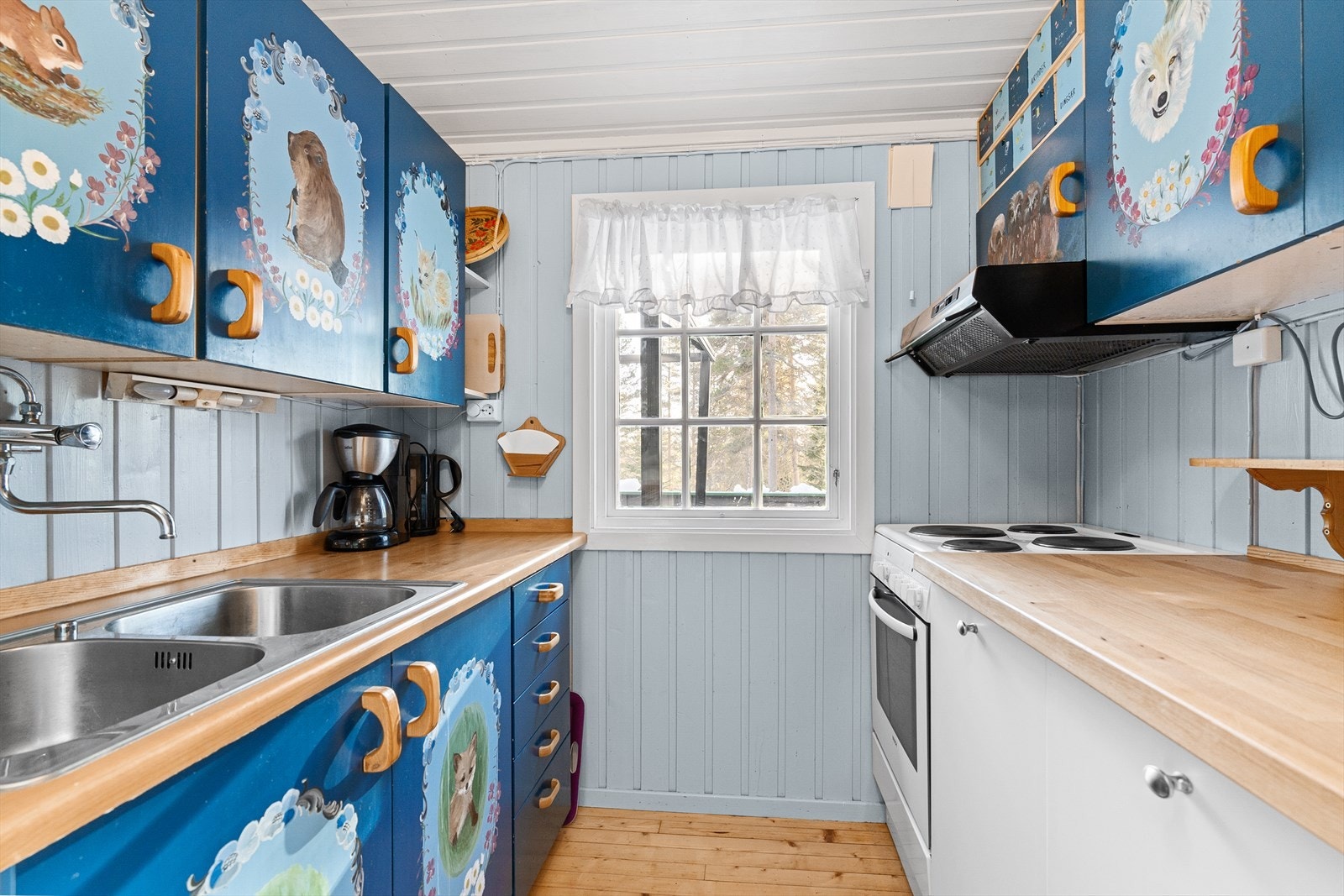 Lekkert kjøkken med håndmalte motiver på frontene. Her kan man kose seg med barnebarna, og drive historefortelling mens man lager mat. Galleribilde