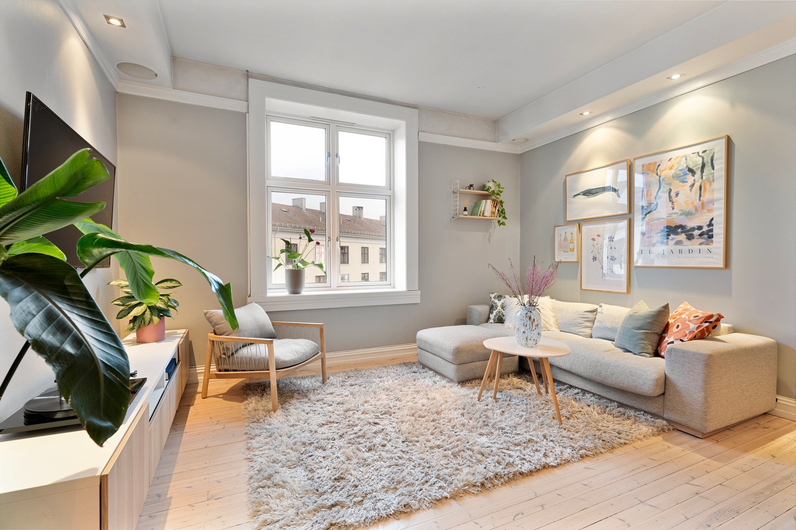 Leilighetens stue fremstår som vært romslig og åpen, med flere møbleringssoner. Galleribilde