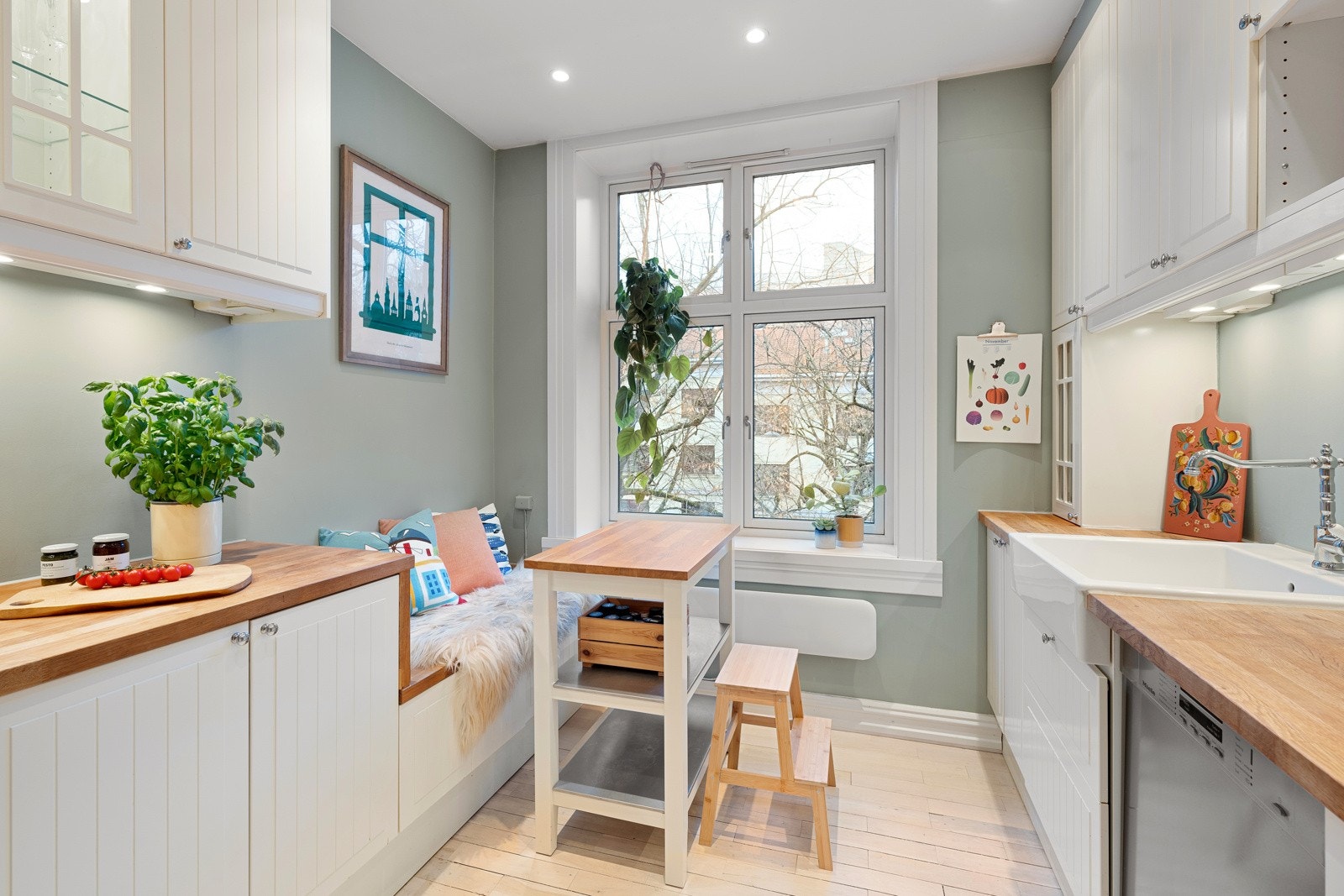 Hyggelig kjøkken med kjøkkeninnredning med profilerte fronter og benkeplate av tre. Galleribilde