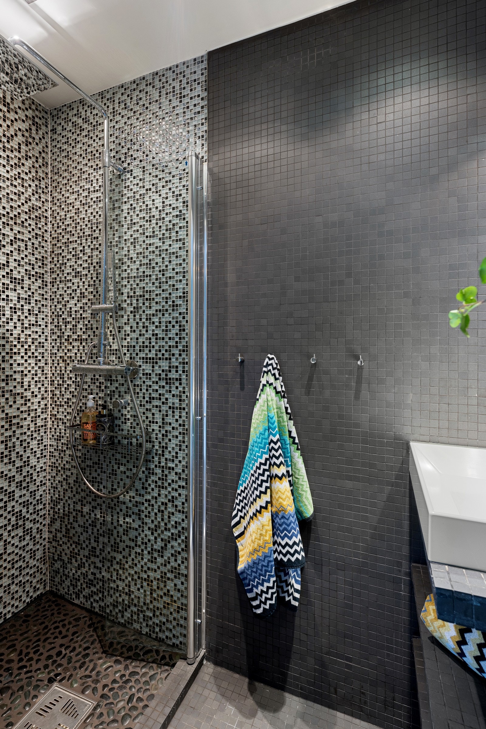 Tidsriktig, flislagt bad med en flott baderomsinnredning og dusj med både hånd- og regndusj. Galleribilde