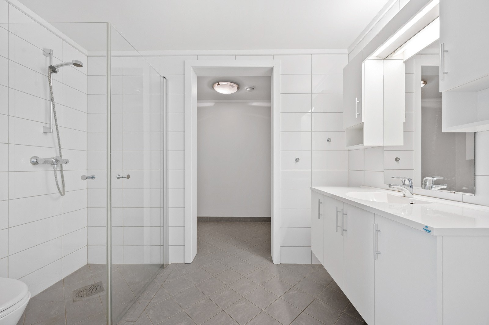 Tidløst og lekkert bad med praktisk vaskeromsløsning i bakkant. Badet og vaskerom har gulvvarme. Galleribilde