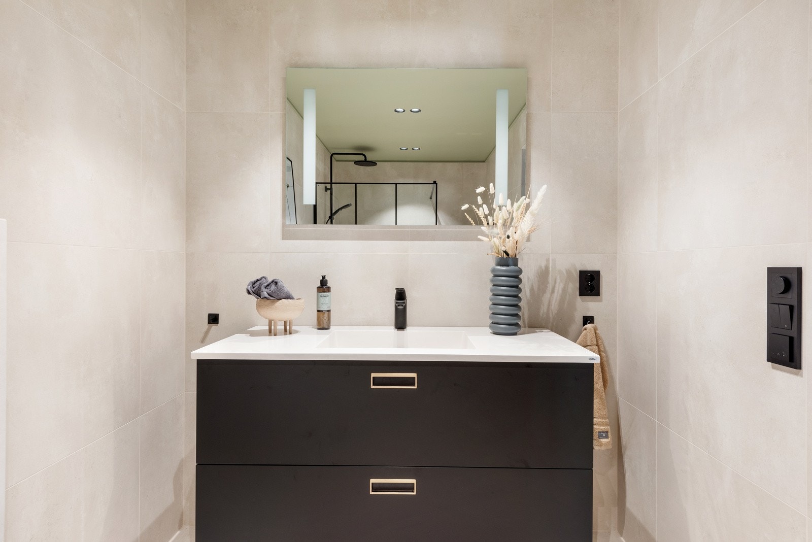 Badet er innredet med stort servantskap, vegghengt wc, dusjhjørne med glassvegg og slukrenne Galleribilde