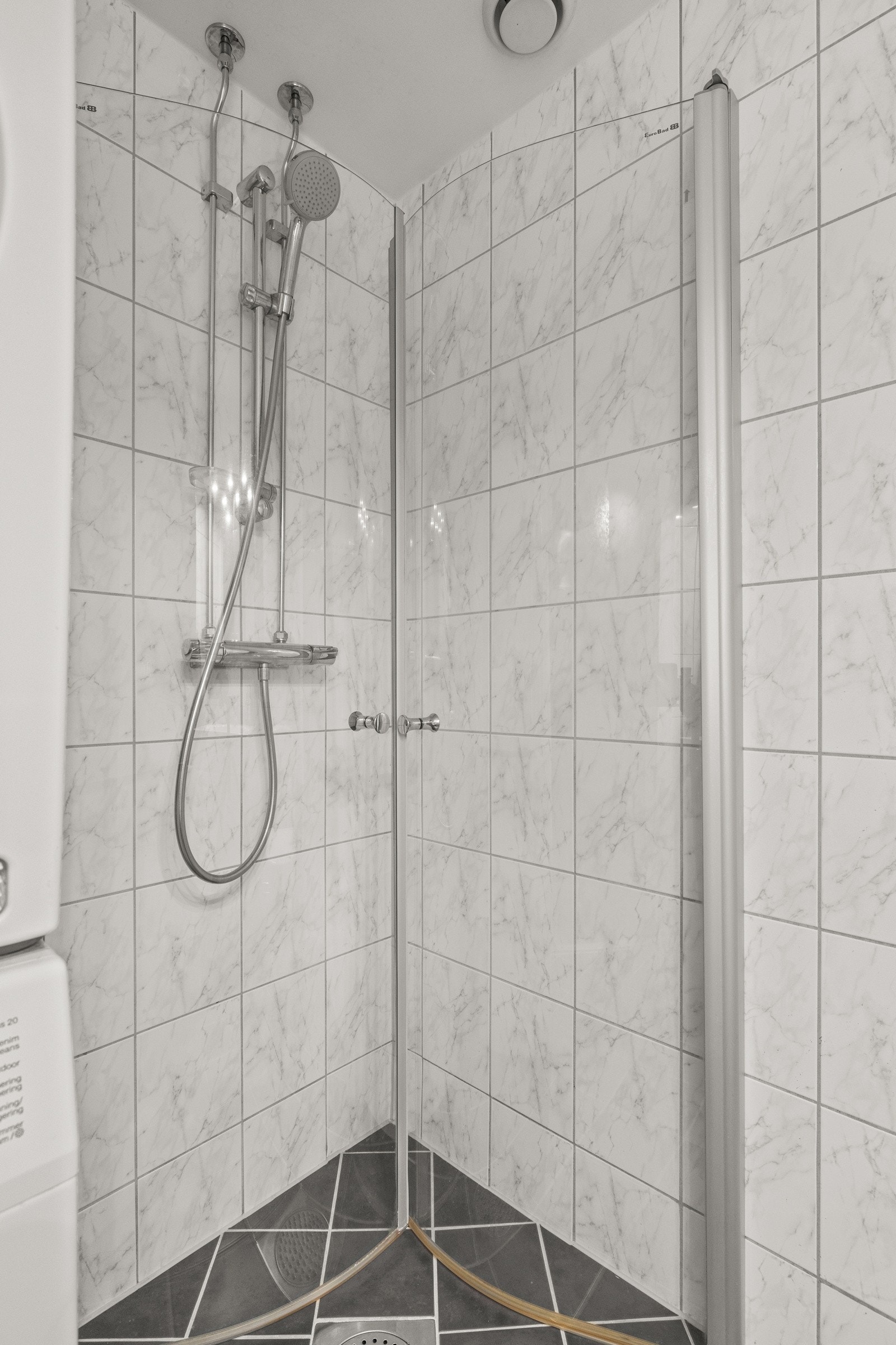 Dusjhjørne svingbare dusjdører av herdet glass, dusjbatteri og dusjgarnityr med hånddusj. Galleribilde