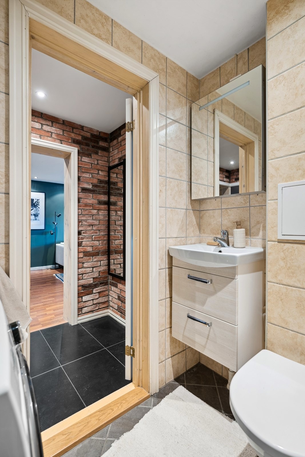 Innredet med servant med oppbevaringsplass, speil med belysning, vegghengt toalett og dusjhjørne. Opplegg for vaskemaskin. Galleribilde