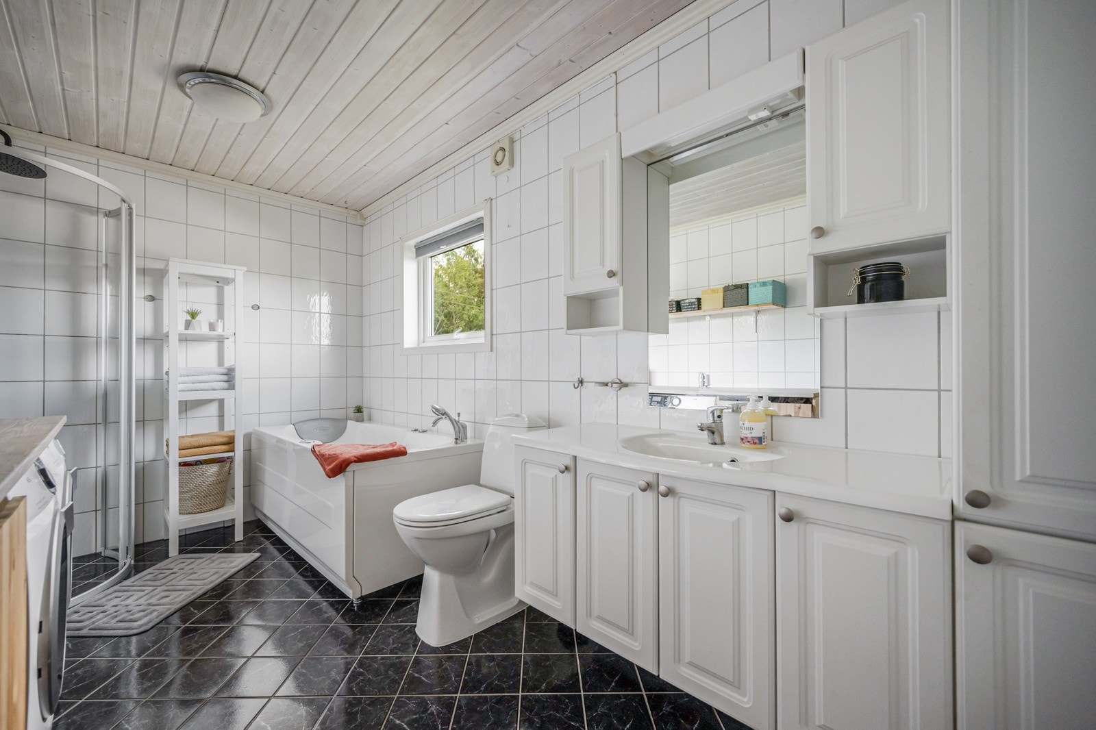 Badet har flislagte gulv og vegger Galleribilde