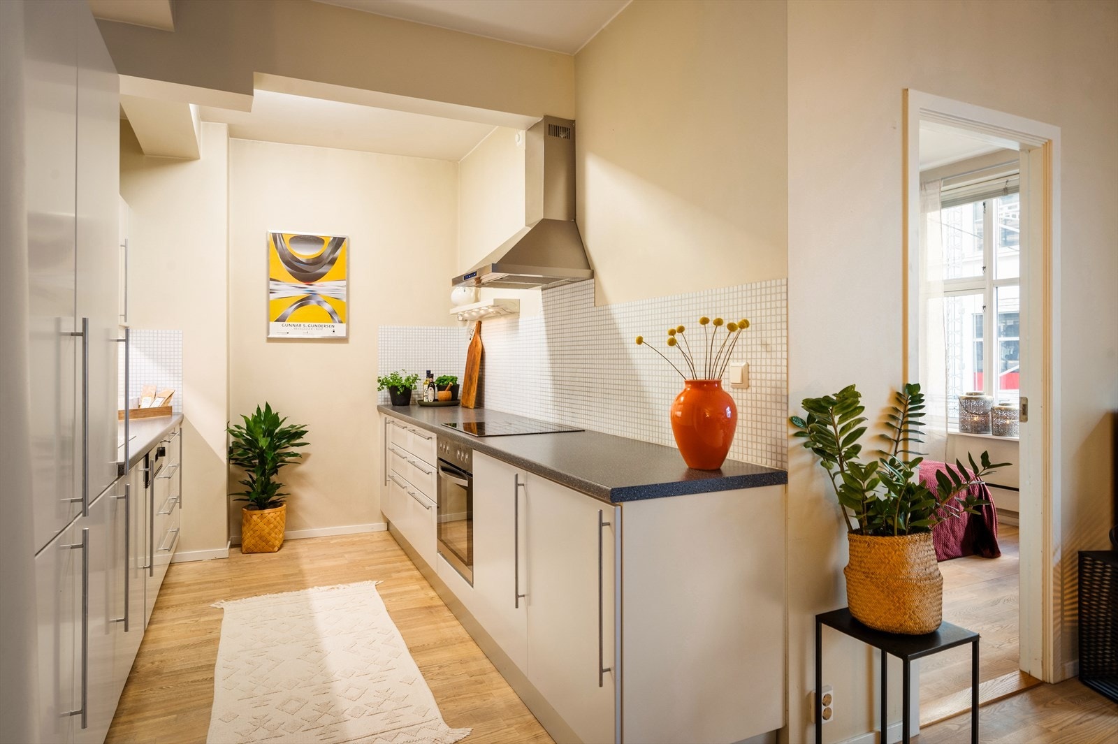 Kjøkkenet er utstyrt med hvite, slette fronter og en laminat benkeplate med nedfelt benkebeslag og ett-greps blandebatteri. Galleribilde