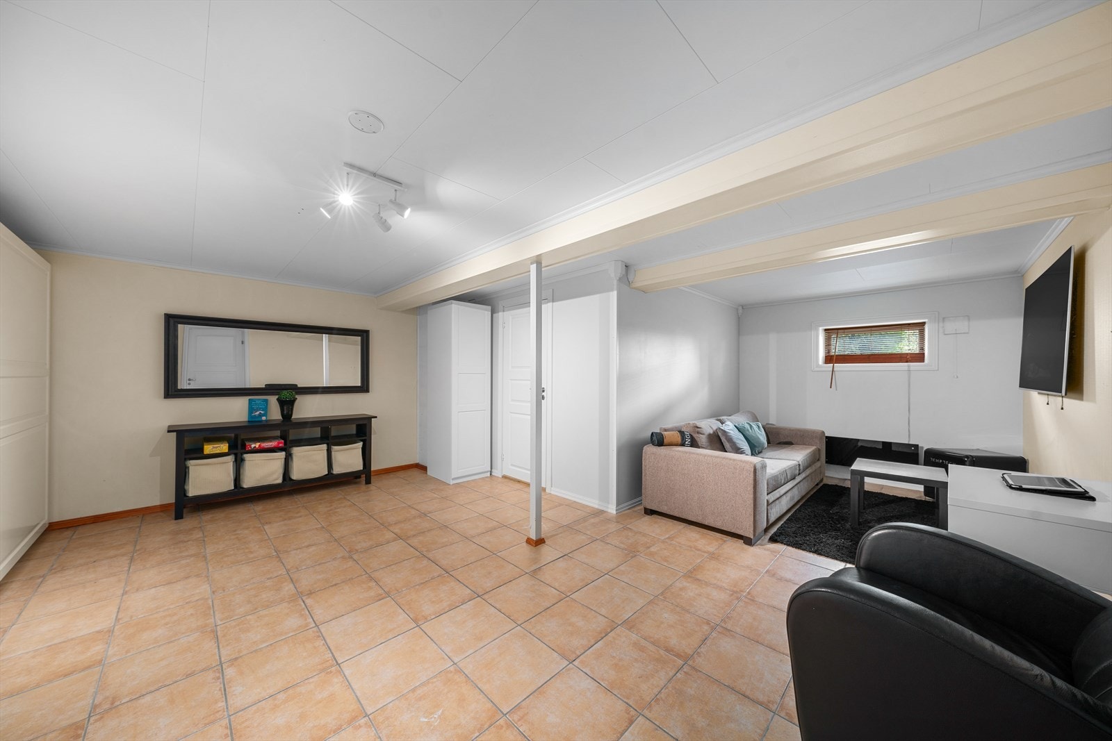 I kjelleretasjen er det blitt innredet en stue, men arealet i etasjen er ikke godkjent for varig opphold (se punktet Ferdigattest for mer informasjon). Galleribilde