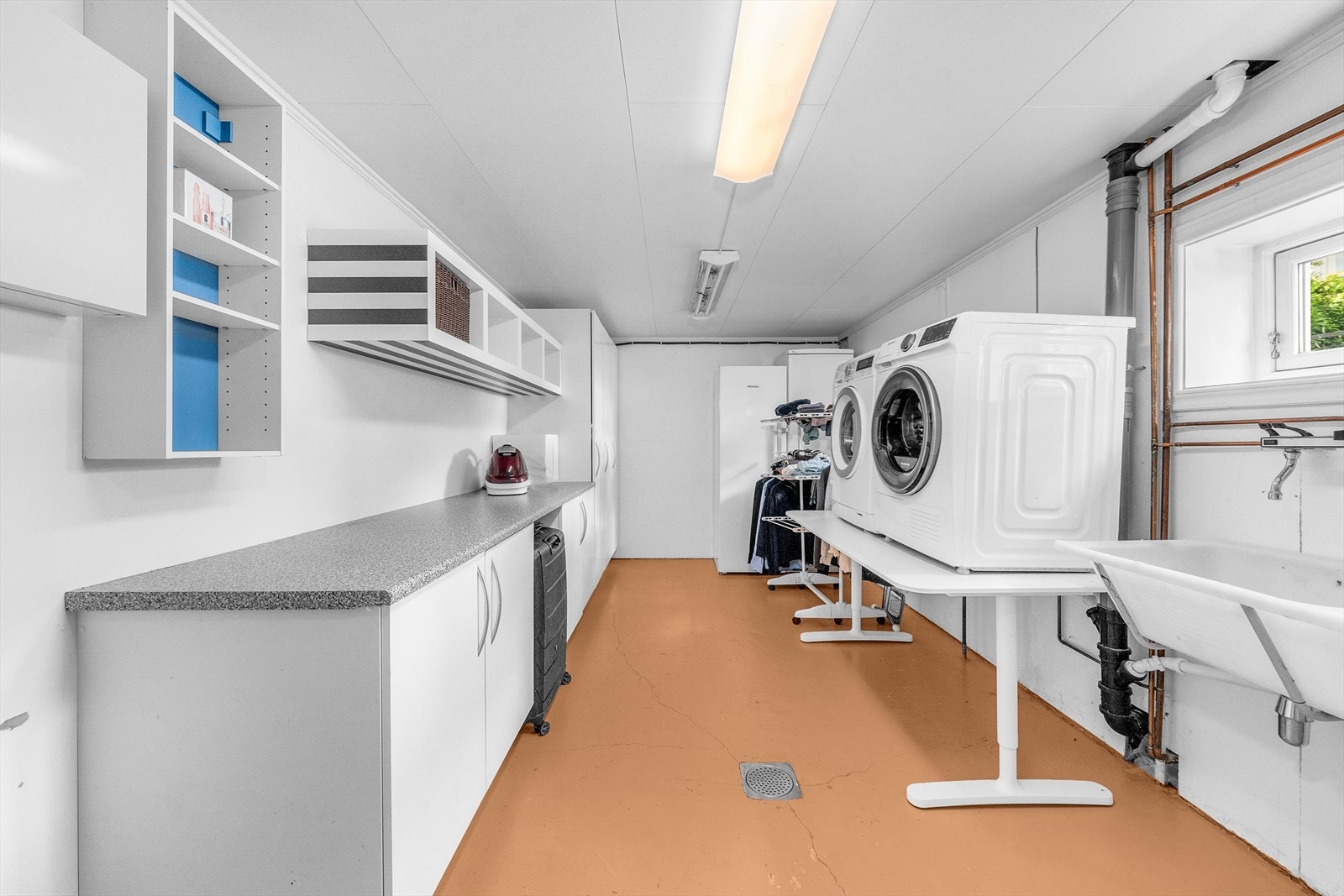 Fra kjelleren er det inngang til et et romslig vaskerom med smart innredning, skyllekum i plast, varmtvannsbereder, samt opplegg for både vaskemaskin og tørketrommel. Galleribilde