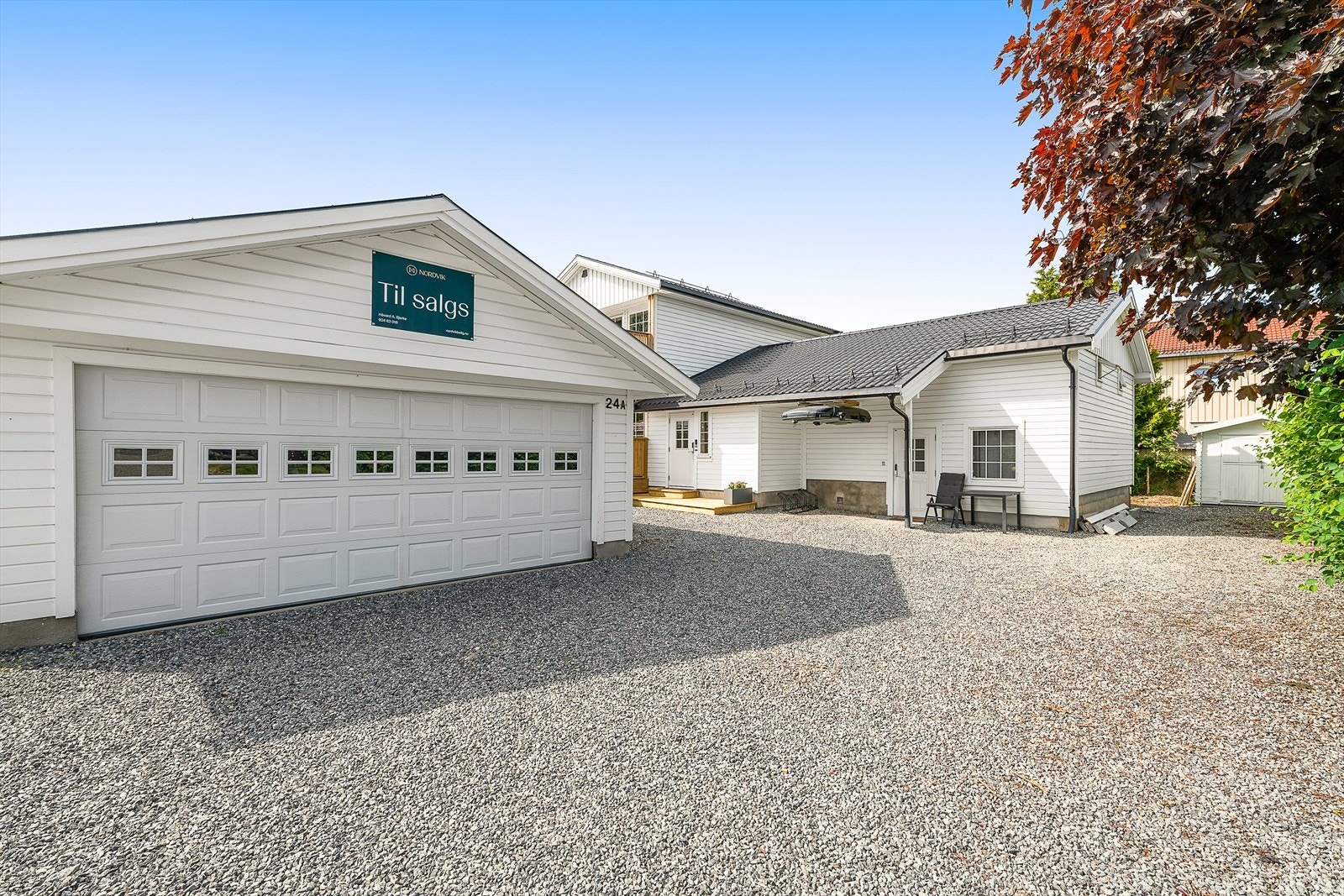 Stor dobbeltgarasje med elektrisk port. Det er plass til mange biler på gårdsplassen. Galleribilde