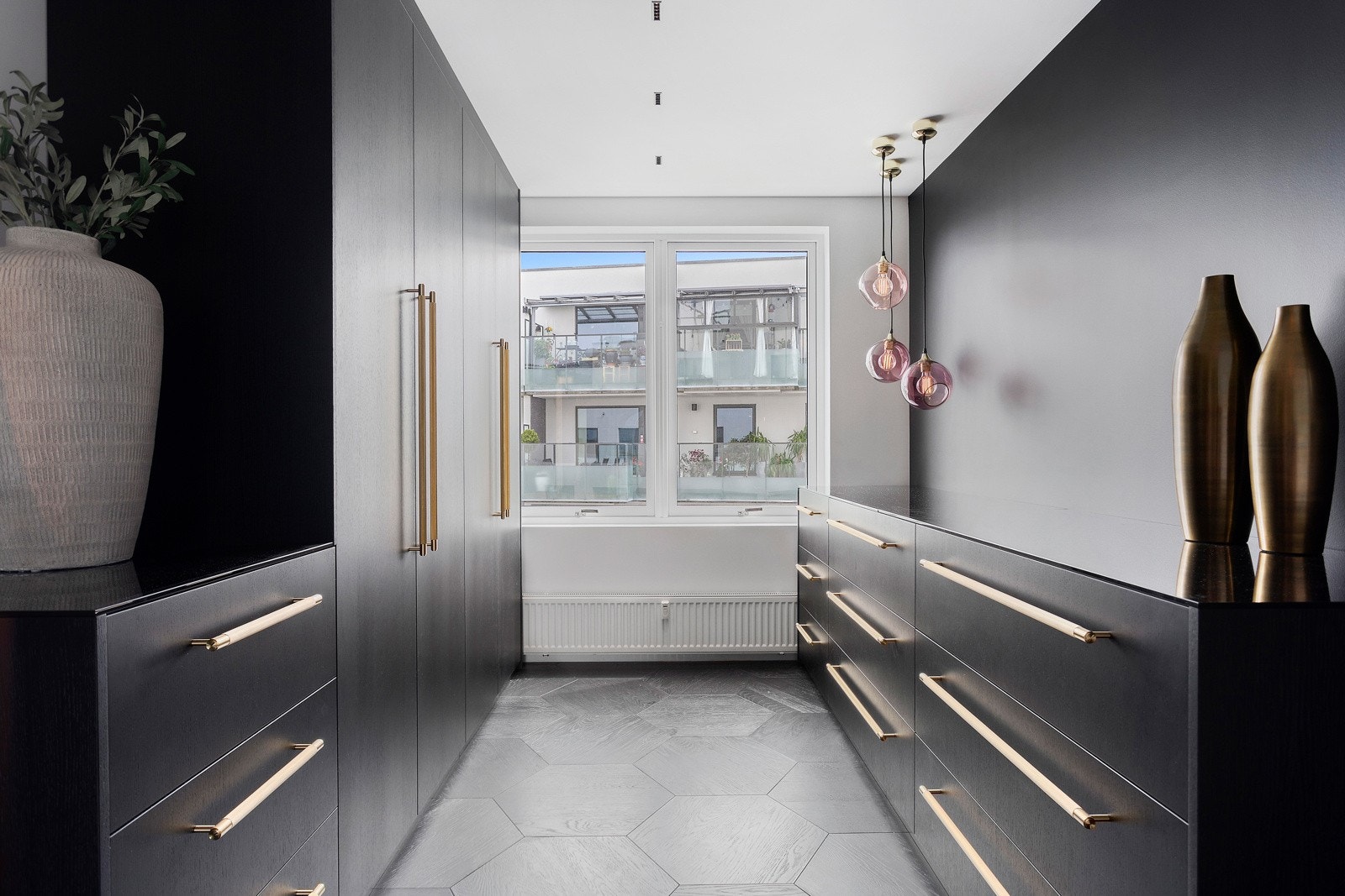Yttertøyet kna du henge fra deg i spesial designet garderobe i matt sort, med lekre gulldetaljer Galleribilde