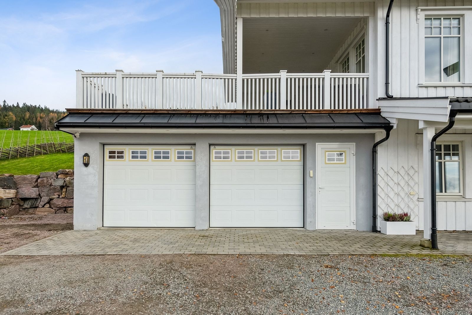 Integrert dobbelgarasje med elektriske leddporter under den generøse uteplassen. Galleribilde